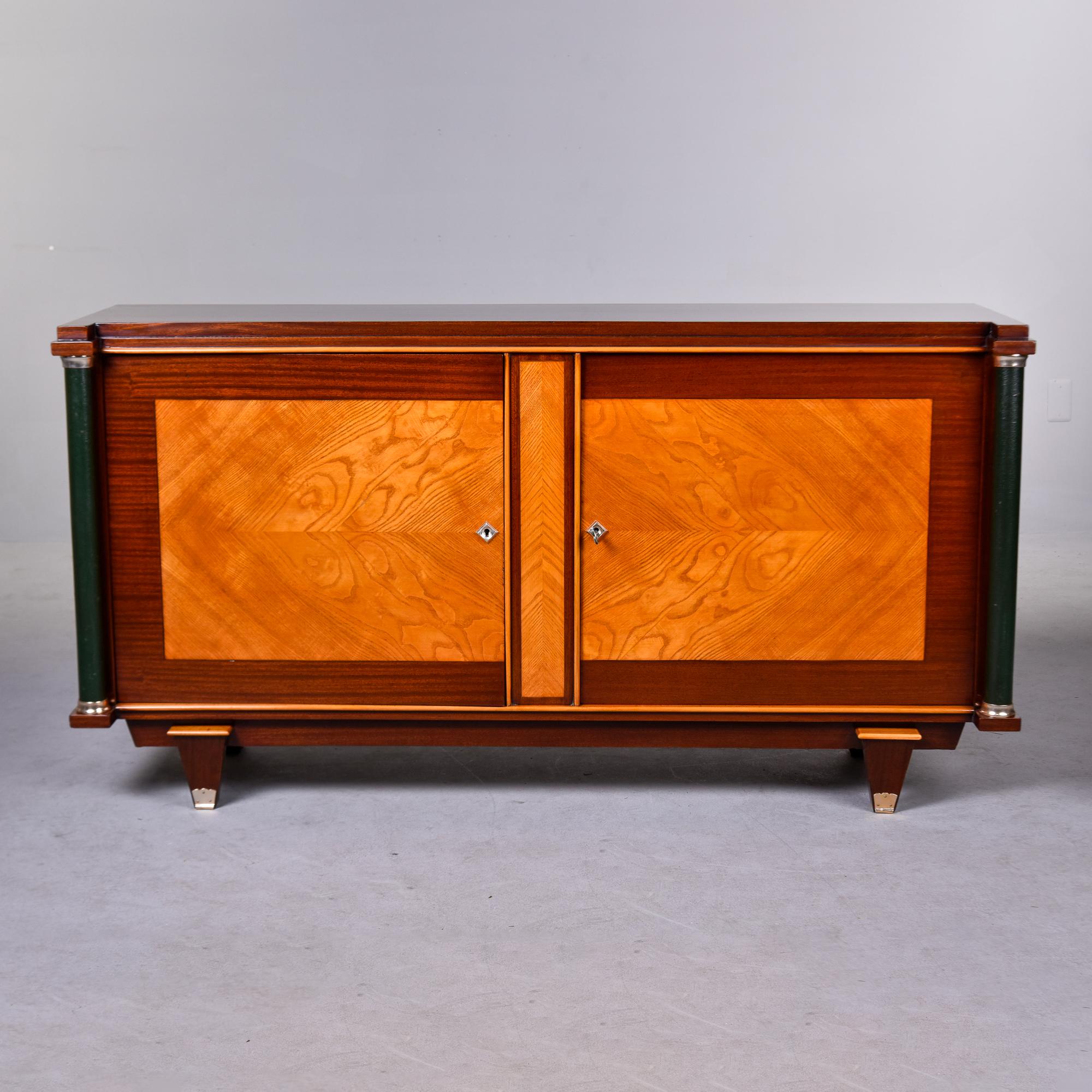 French Art Deco polished mahogany cabinet with leather covered pillar detail.

Found in France, this buffet cabinet or credenza dates from the 1930s. Dark polished mahogany and a contrasting, lighter wood that we believe is maple or a blond