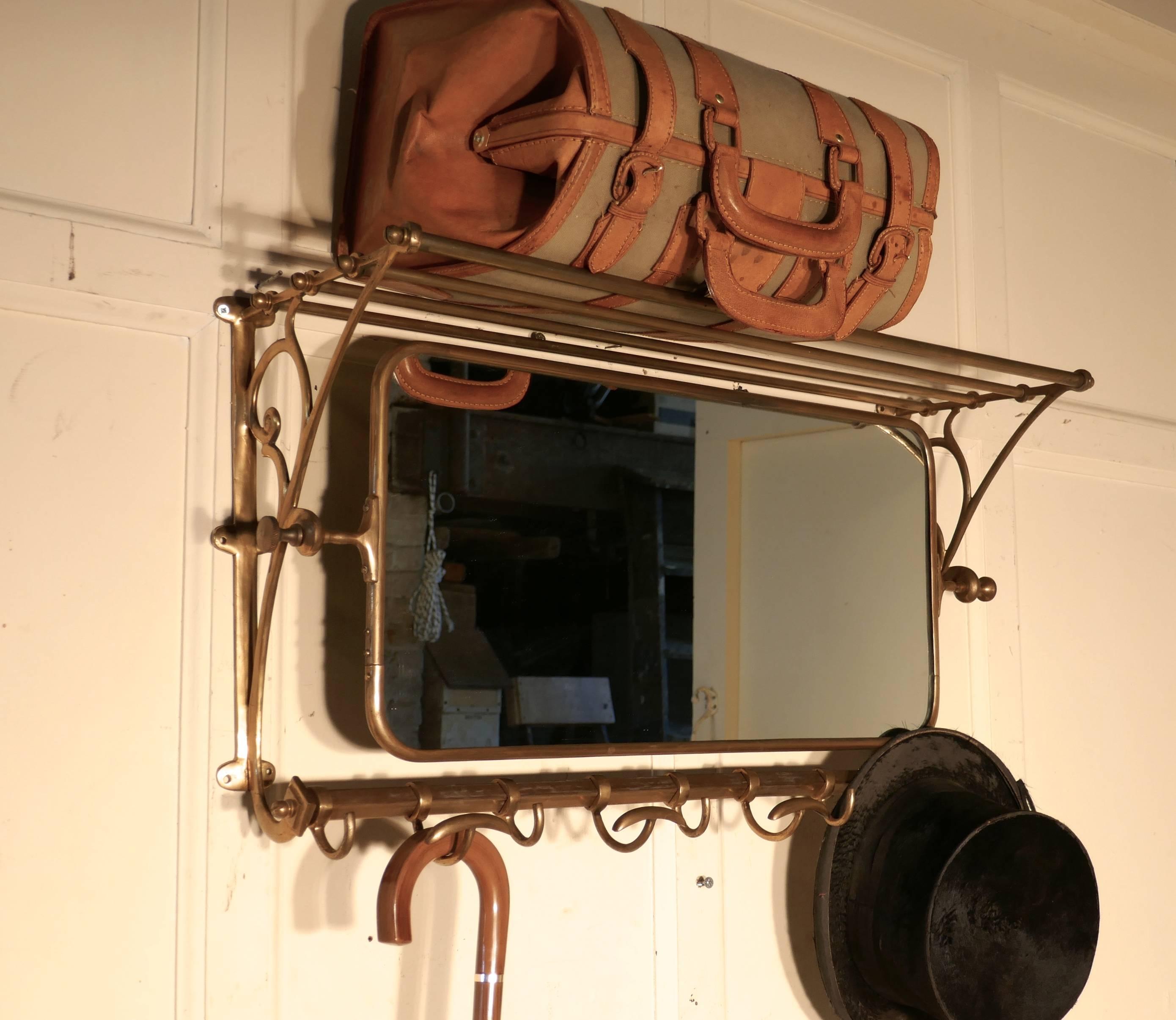 French Art Deco Pullman hat and coat mirror from a train 

This Art Deco period brass train rack includes its original bevelled swivel mirror that adjusts to the proper angle for viewing, it has nine sliding hooks and an upper shelf
Originally