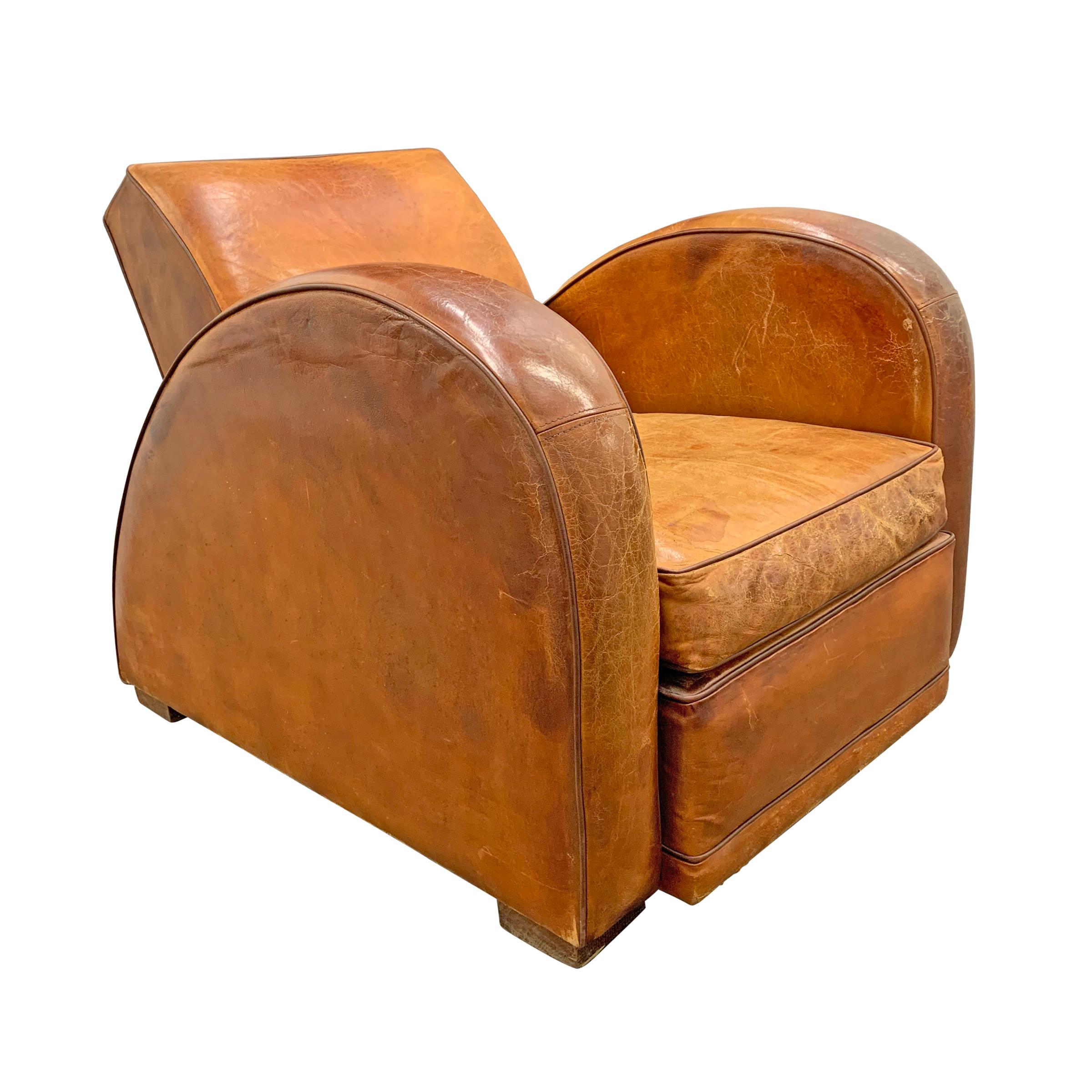 An extraordinary early 20th century French Art Deco race-car form club chair with gorgeous curves, the perfect pitch, and wonderfully worn leather upholstery.