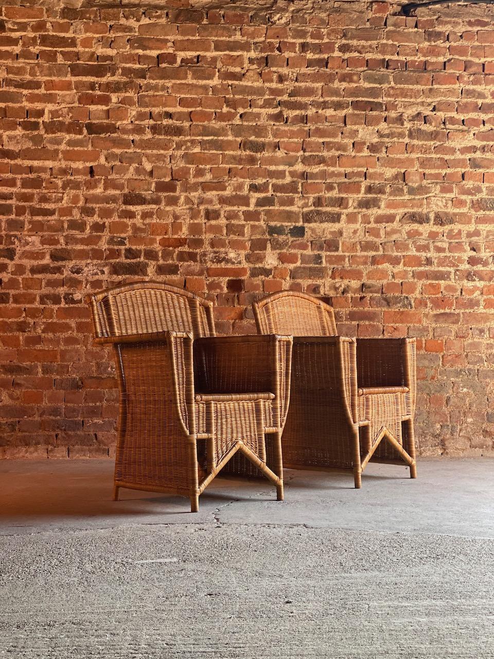 Stunning pair of French Art Deco design rattan wicker armchairs with bamboo frames France circa 1960s, the high rounded backs with wide armrests and deep generous geometric design frames make these chairs extremely comfortable, typical classic