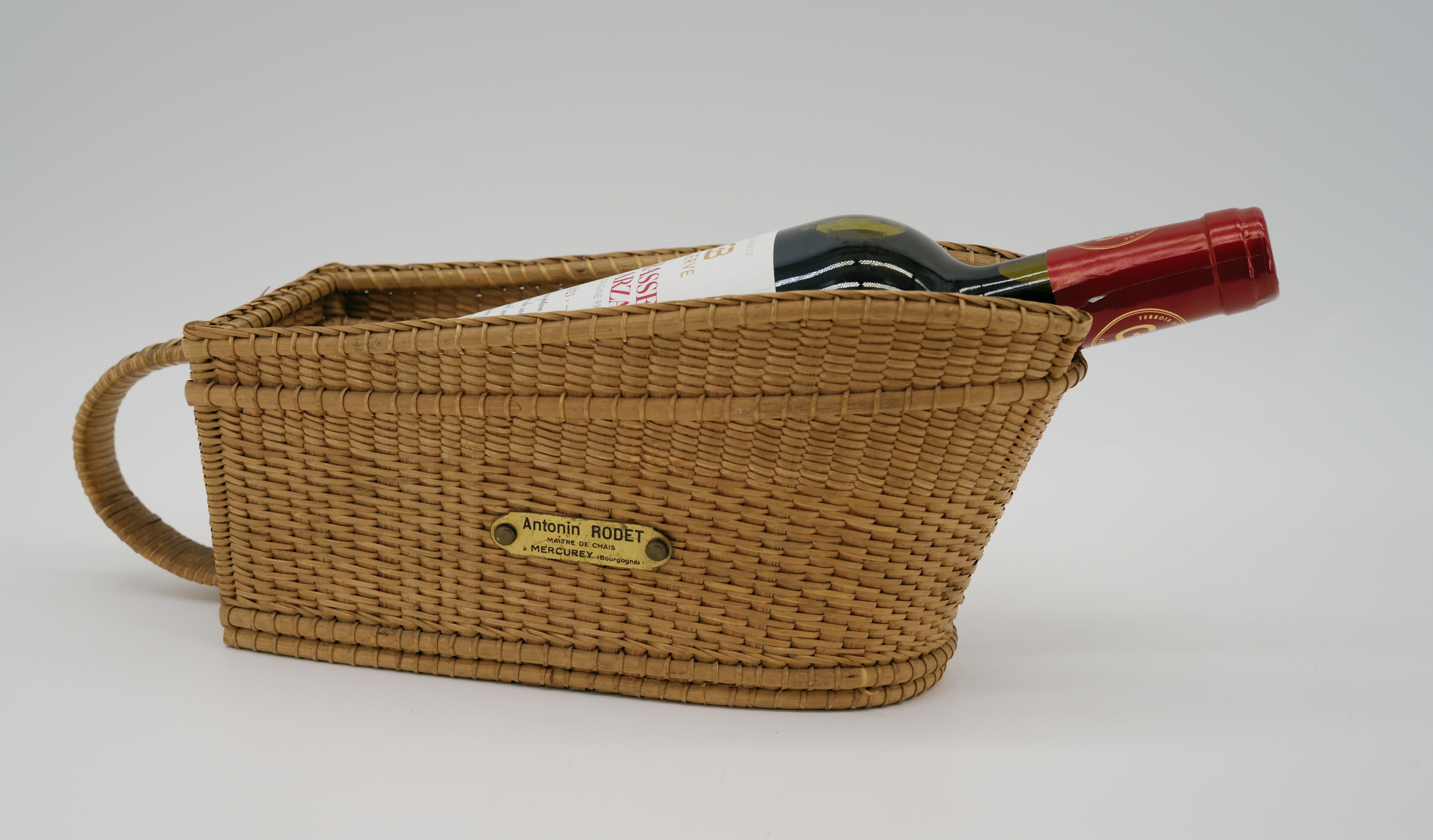 French Art Deco Rattan Wine Bottle Holder, 1920s. Rattan and brass. 4.8 in.Hx12.8 in.Wx4.33 in.D - 12.2 cmHx32.5 cmWx11 cmD. Brass plaque 