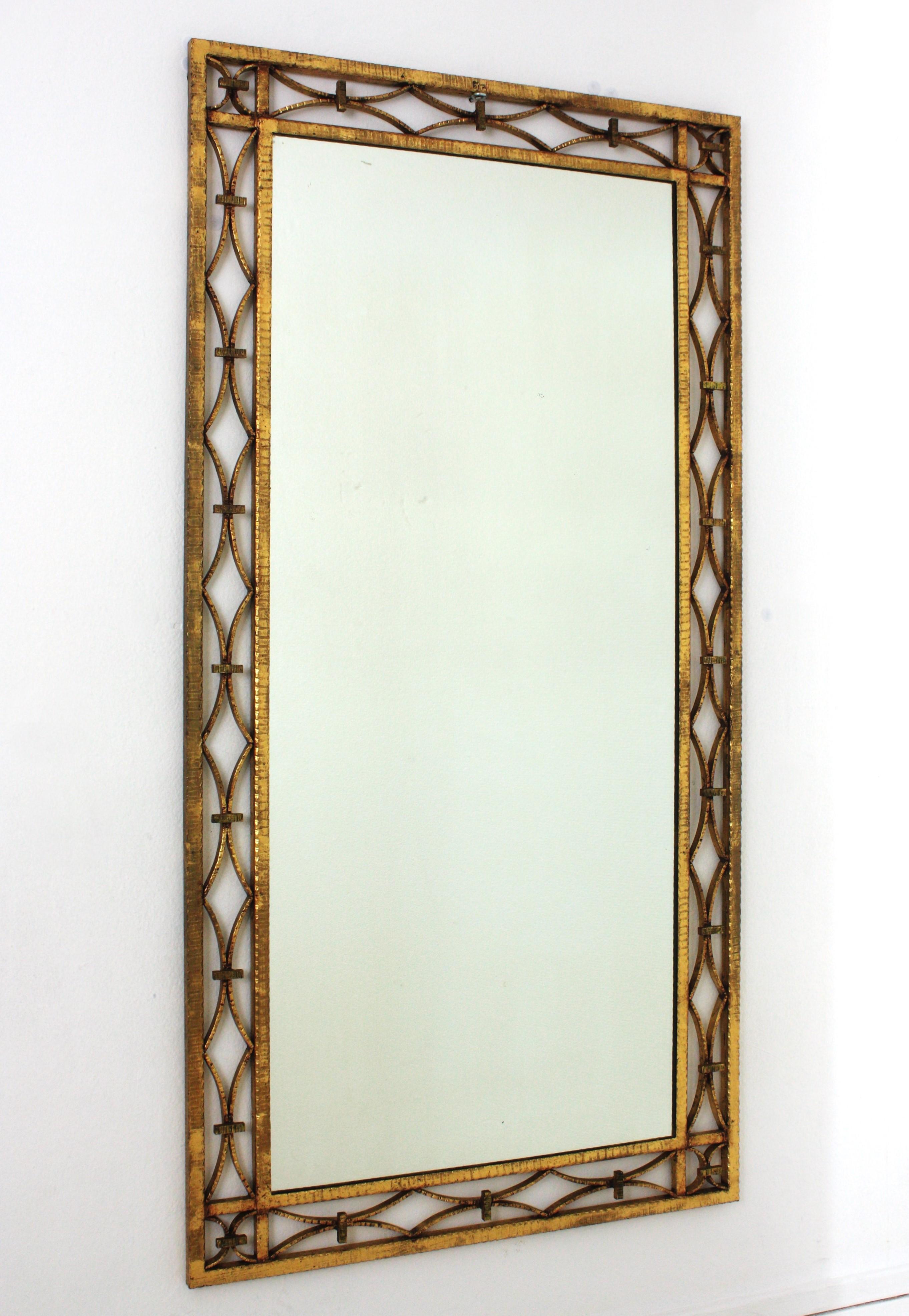 Gilt Rectangular Wall Mirror, Wrought Iron, Gold Leaf
French Art Deco wrought iron mirror with intricate geometric motifs, France, 1940s.
Eye-catching hand forged iron mirror with geometric decorations on the frame and a gorgeous design in