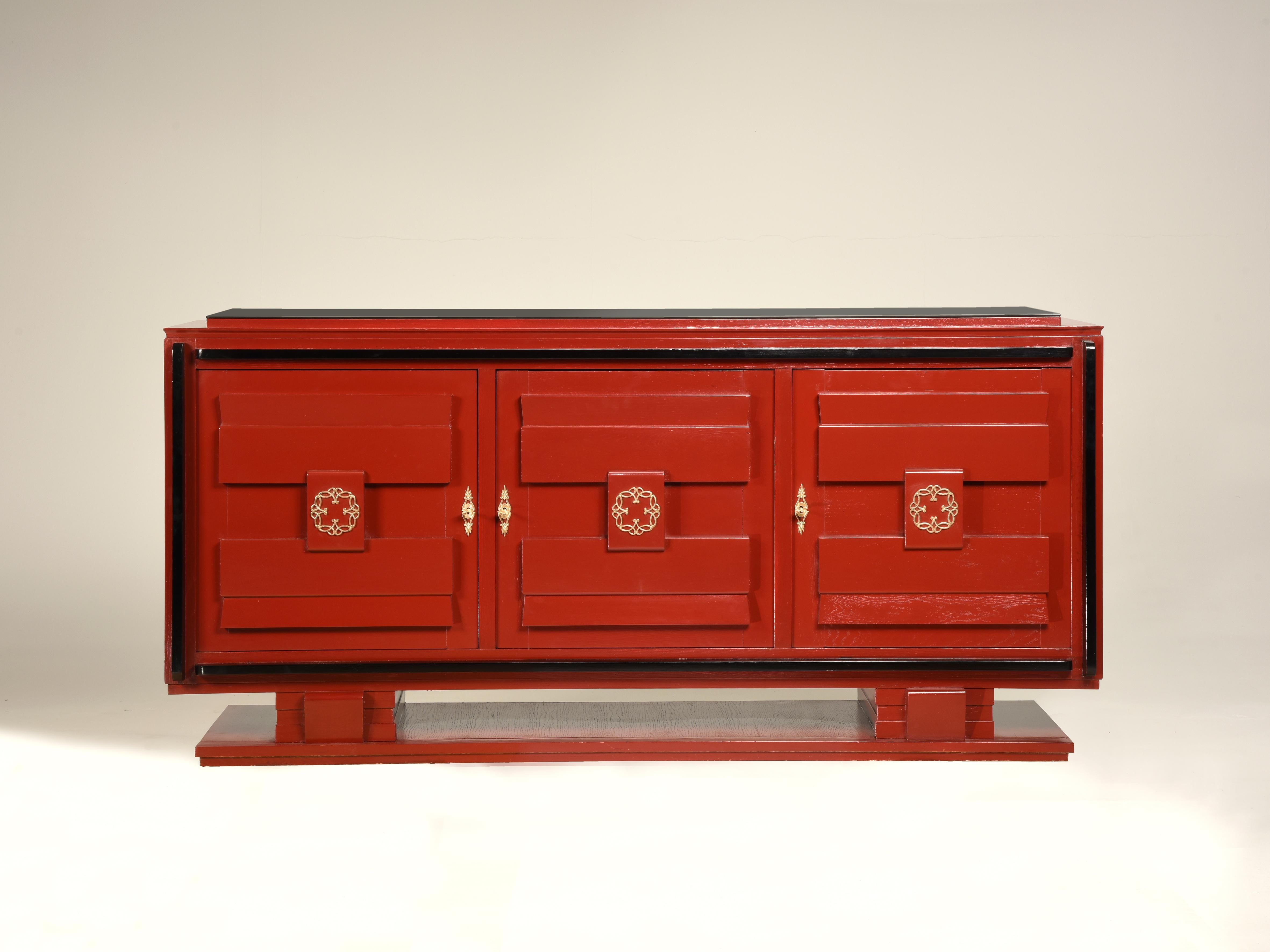 French 1940s Art Deco style red lacquered and black details and top credenza

French Art Deco sideboard. Red lacquer and black ebonized details. Three doors and brass hardware. Internally the doors are arranged with shelves and one drawer. The top