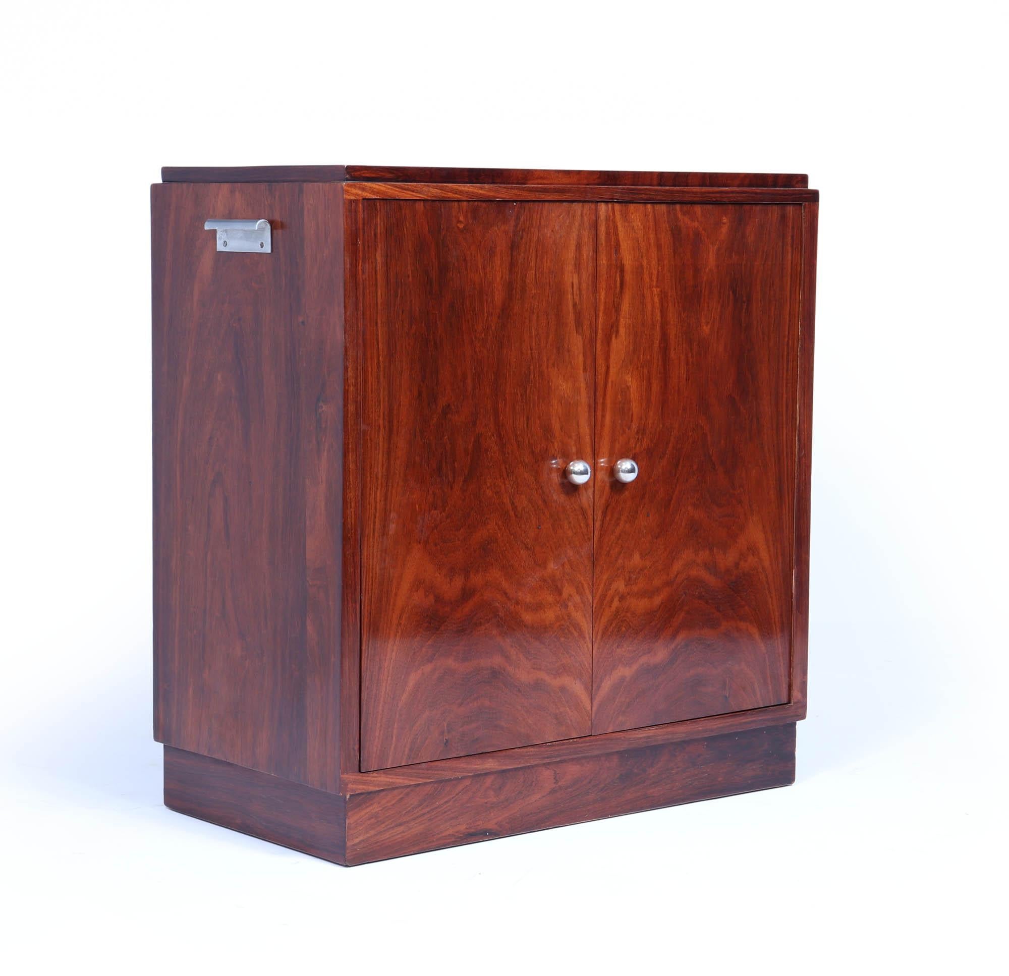 This compact walnut cocktail cabinet, crafted in France during the 1920s, features a rotating door that opens to reveal three demi lune glass shelves. the cupboard on the right has a fixed shelf. The piece has been French polished and remains in