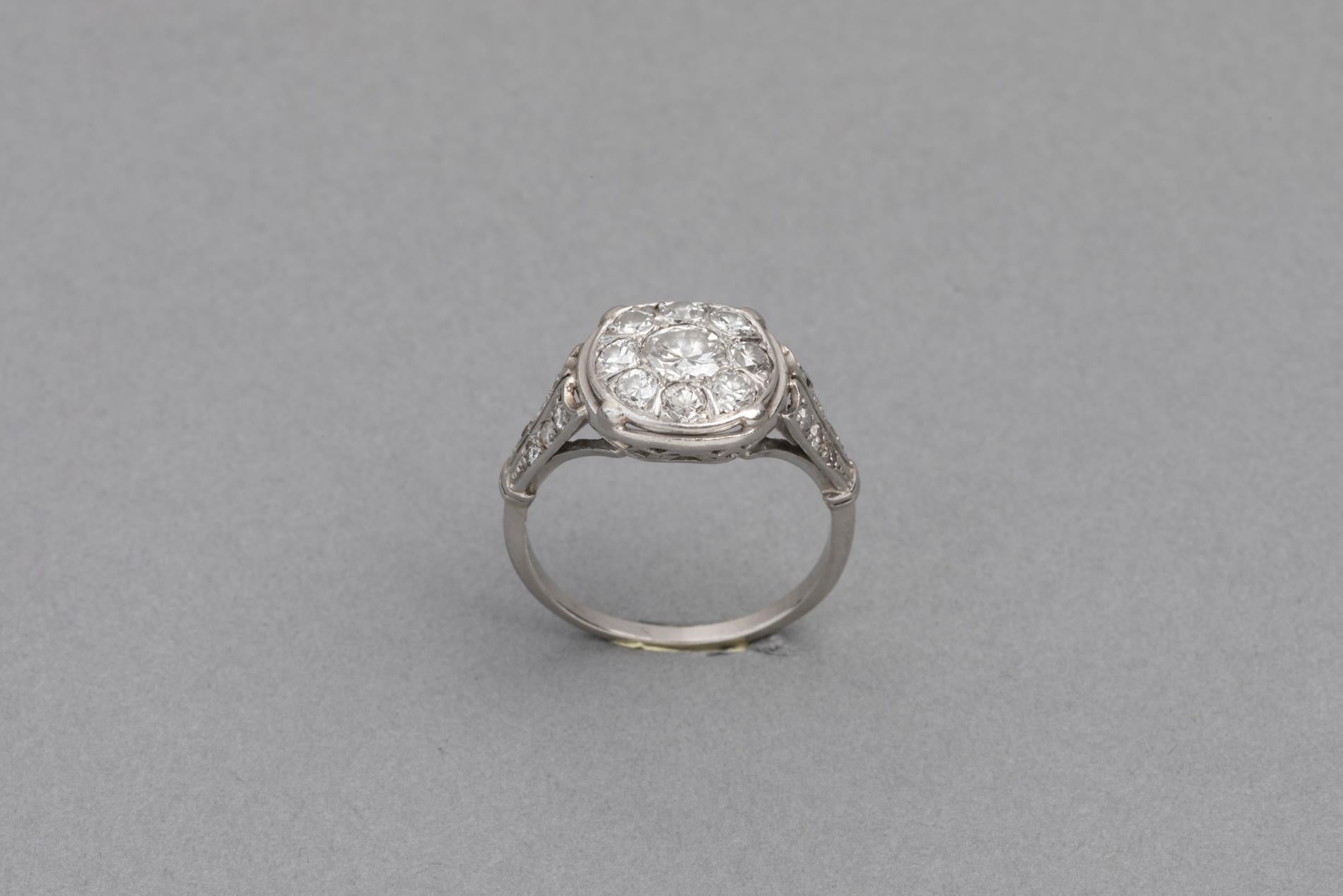 Lovely designed  antique ring, made in France circa 1920. 

The Diamonds are white and clear. They shine very well.

Mounted with platinum and good quality old European cut diamonds. French official marks for Platinum (The old man).

The central