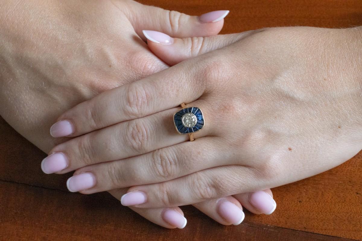 Un anillo geométrico único con zafiros y un diamante.

Origen: Francia, primera mitad del siglo XX, se conserva el sello.

El anillo está fabricado en oro amarillo de 18 quilates (ley 0,750).

Engastado centralmente con un diamante talla brillante