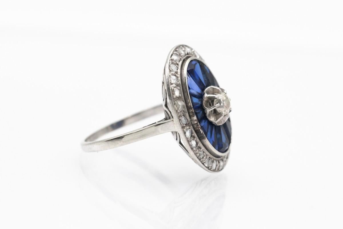 Bellissimo anello a grappolo antico in oro bianco e platino. Il punto centrale è un diamante con taglio a brillante antico del peso di circa 0,20 ct.

Un antico anello di forma ovale decorato con zaffiri sfaccettati con taglio a carrè e numerosi