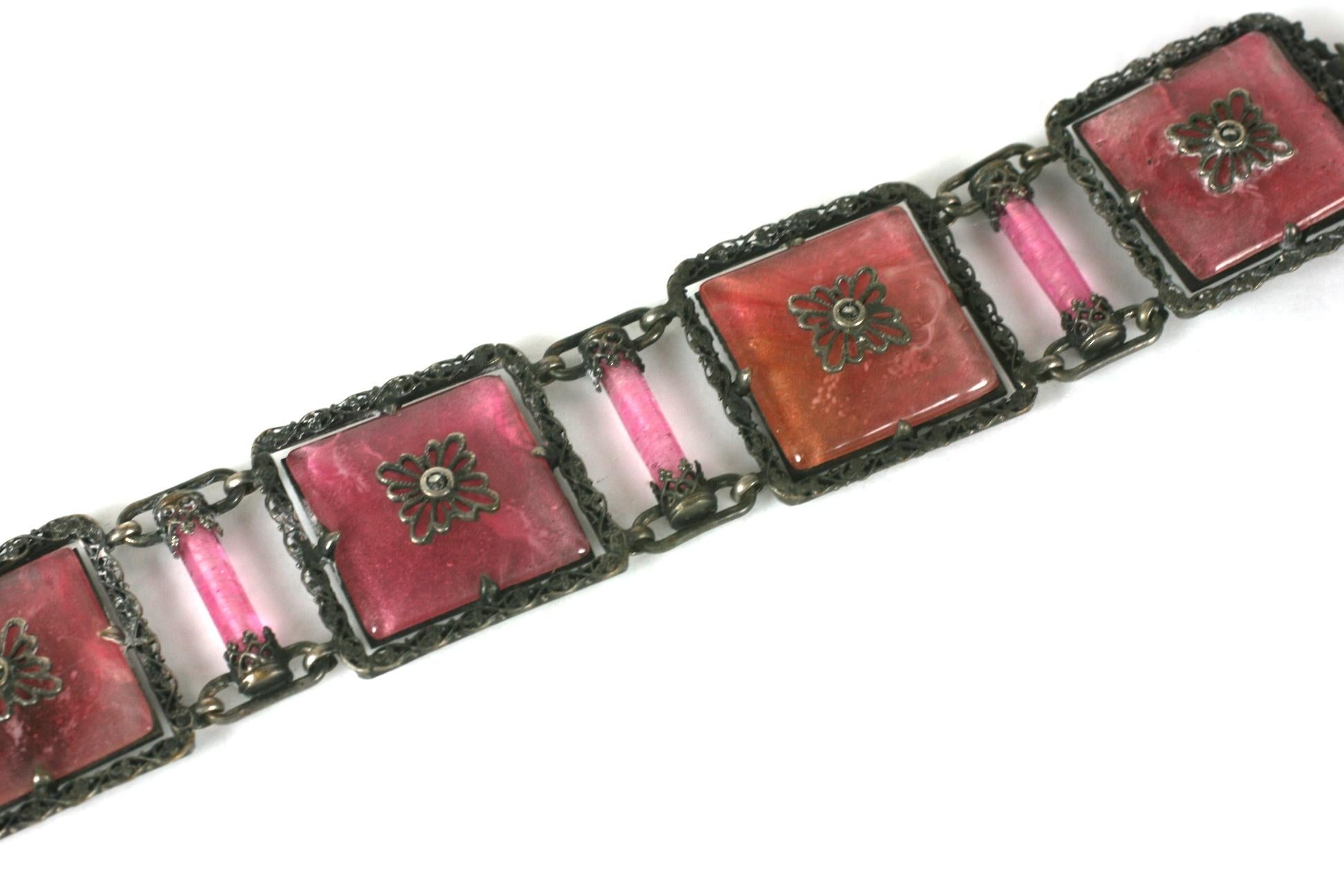Exceptional French Art Deco faux rose quartz pate de verre and marcasite square panel link bracelet. Set in antiqued silvered metal, with marcasite accented floral motifs.
Good Condition. Small chip on one panel. 8