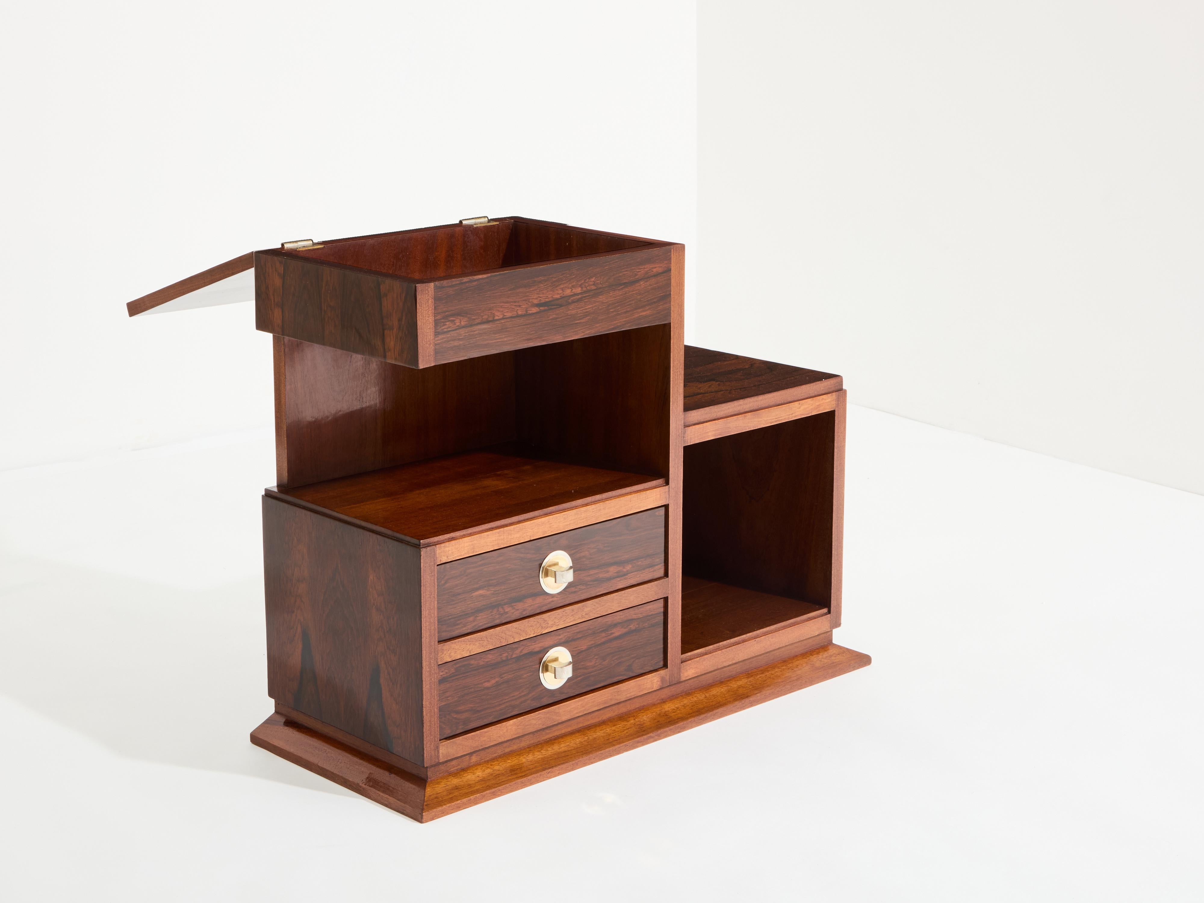 Beautiful Art Deco sewing cabinet fully covered with rosewood veneer dates from the early 1940, and features two drawers and a storage lifting top. This cabinet used to be a sewing cabinet, but would be a lovely addition to a bedroom or a dressing