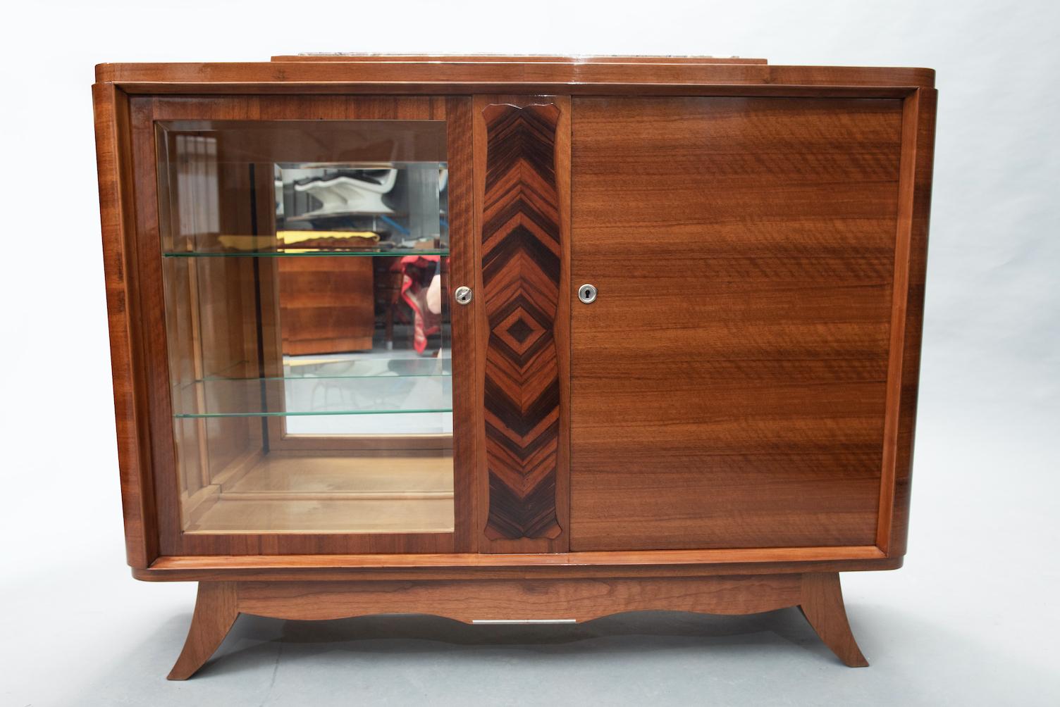 Rosewood and Macassar ebony French Art Deco small sideboard. One of the doors is a display cabinet with glass shelves.
