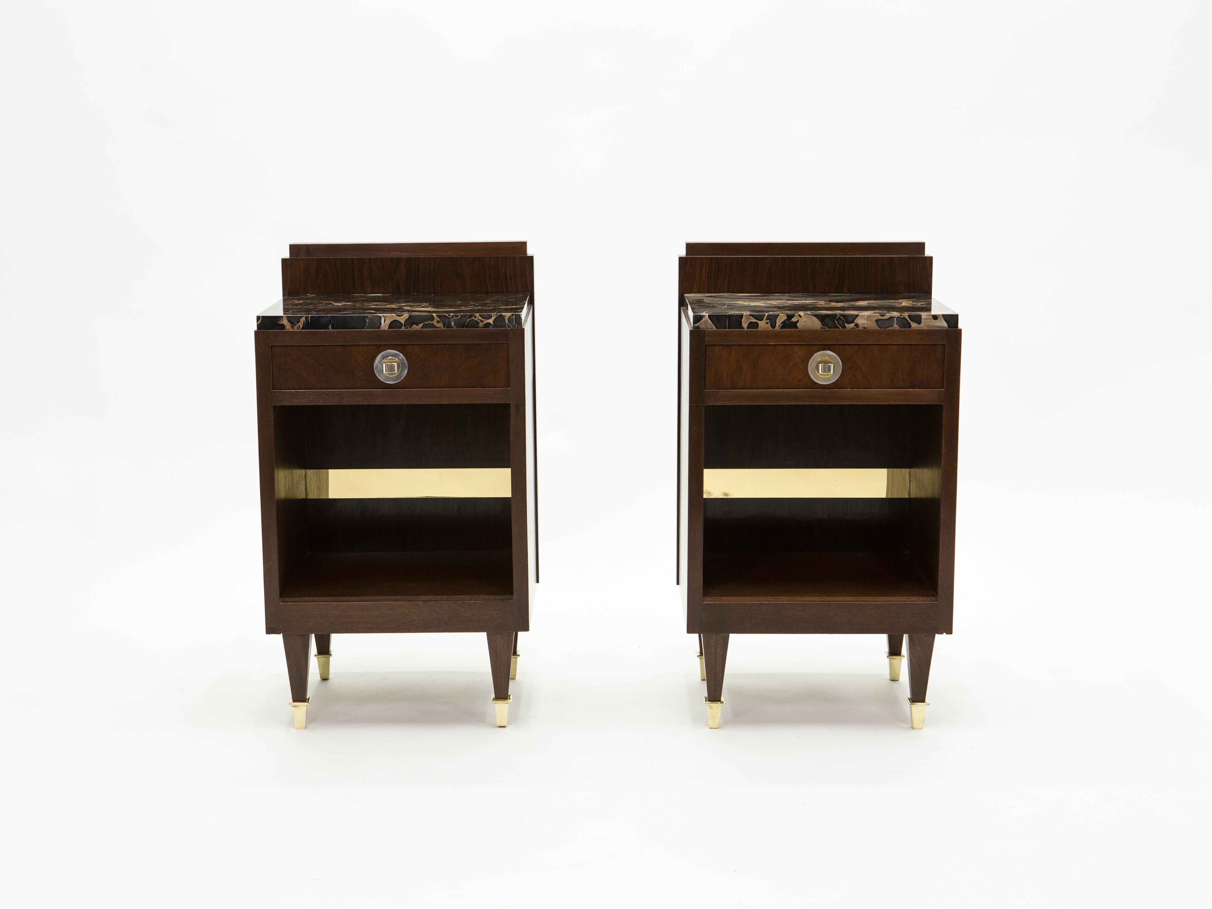 This French Art deco pair of nightstands is crafted with a beautiful rosewood paired with Portoro marble tops. Pure French art deco creation, featuring one drawer and a niche with brass details, these beautiful pieces would make great staging pieces