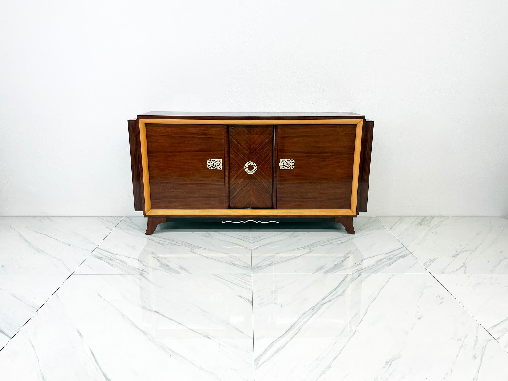 Entra in un'epoca di eleganza e raffinatezza senza tempo con questa splendida credenza francese Art Déco degli anni '40, un capolavoro che evoca l'età dell'oro del design e dell'artigianato. Questo buffet lungo 76