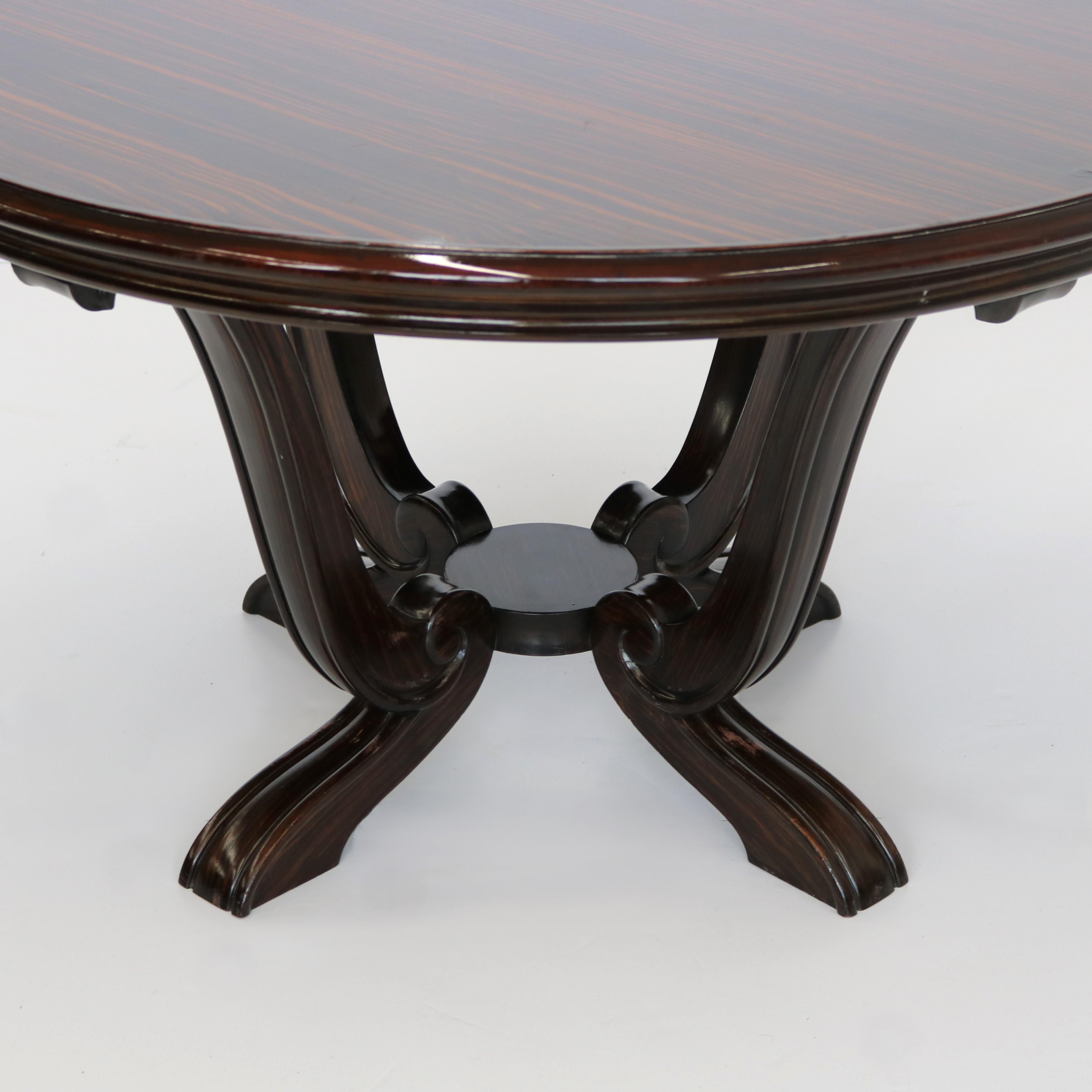 Table de cocktail ronde d'époque Art Déco, 1930, avec un beau plateau en placage et reposant sur une base à quatre pieds au profil incurvé spectaculaire.