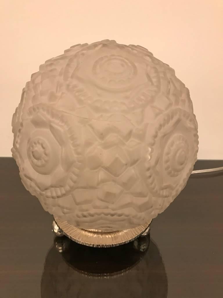 Gorgeous Art Deco table lamp with geometric motif by Sabino. Having a clear frosted geometric glass round shade. Resting on a round nickel-plated deco design frame. Has been rewired for American use. Having one candelabra socket.