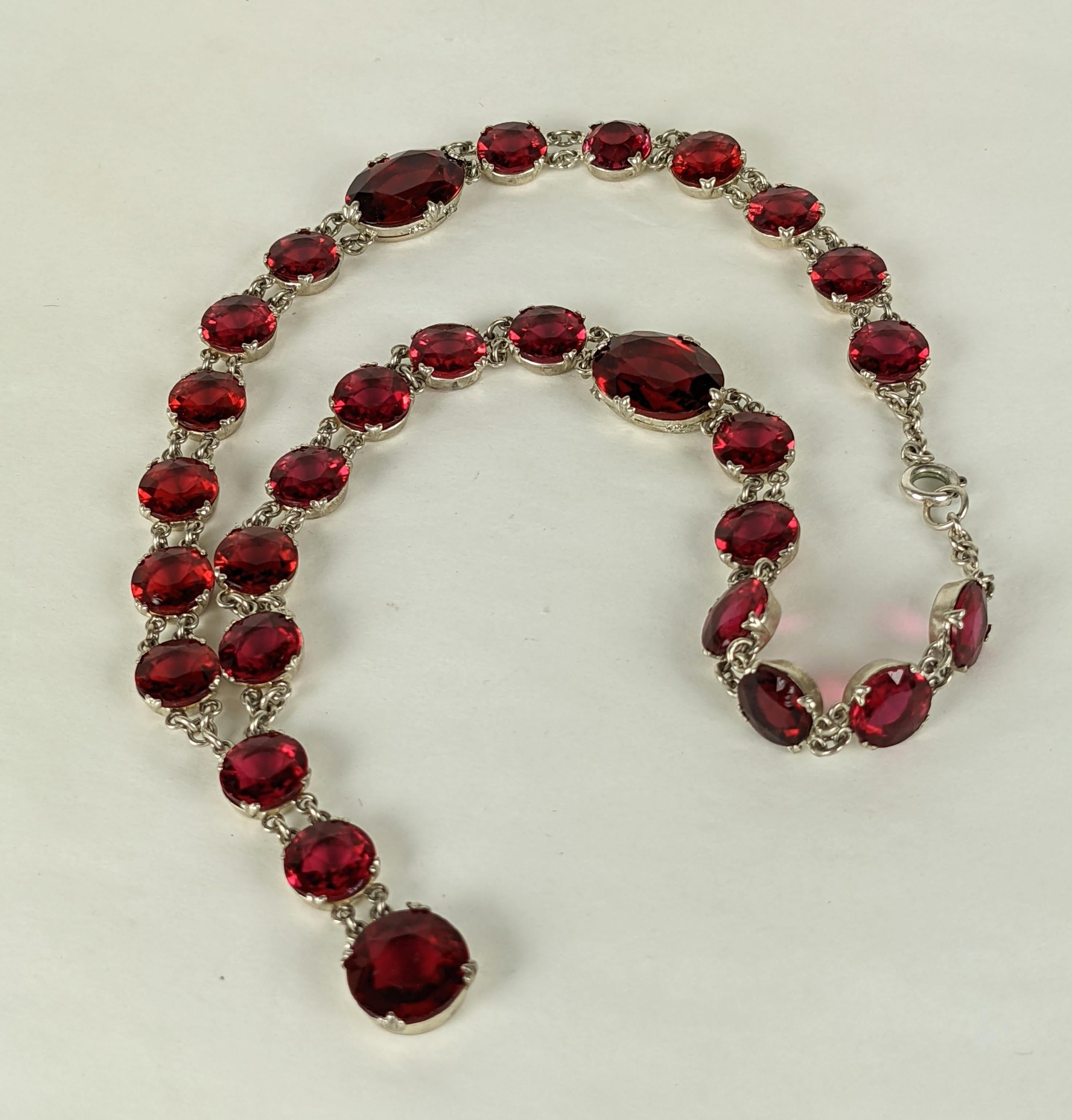 French Art Deco unusual faceted ruby crystal sautoir. Composed of a stone set link chain with two large ovals and twenty six smaller round crystals set in silvered gilt metal with central linked drop. 1920's France.  Excellent Condition. Length 16
