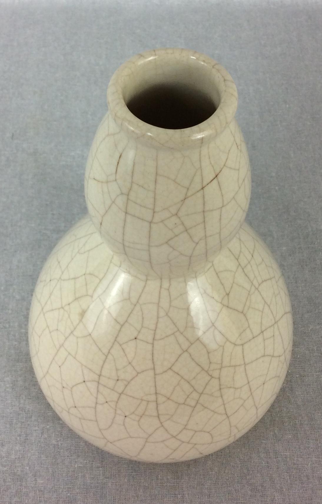 Stunning Art Deco vase by Saint Clement, France. Ceramic vase with white crackle glaze finish. Features an elongated squash shape with narrow opening in a stylized pattern. The crackle clear glaze was a popular technique for animal and figural