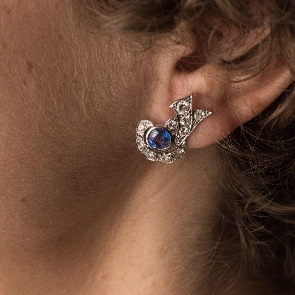 For pierced ears.
Pair of platinum earrings, dog head hallmark and 18 carat white gold, eagle head hallmark.
In the form of bows, these Art Deco earrings are bezel set with round sapphires in openwork settings with antique brilliant cut diamonds.