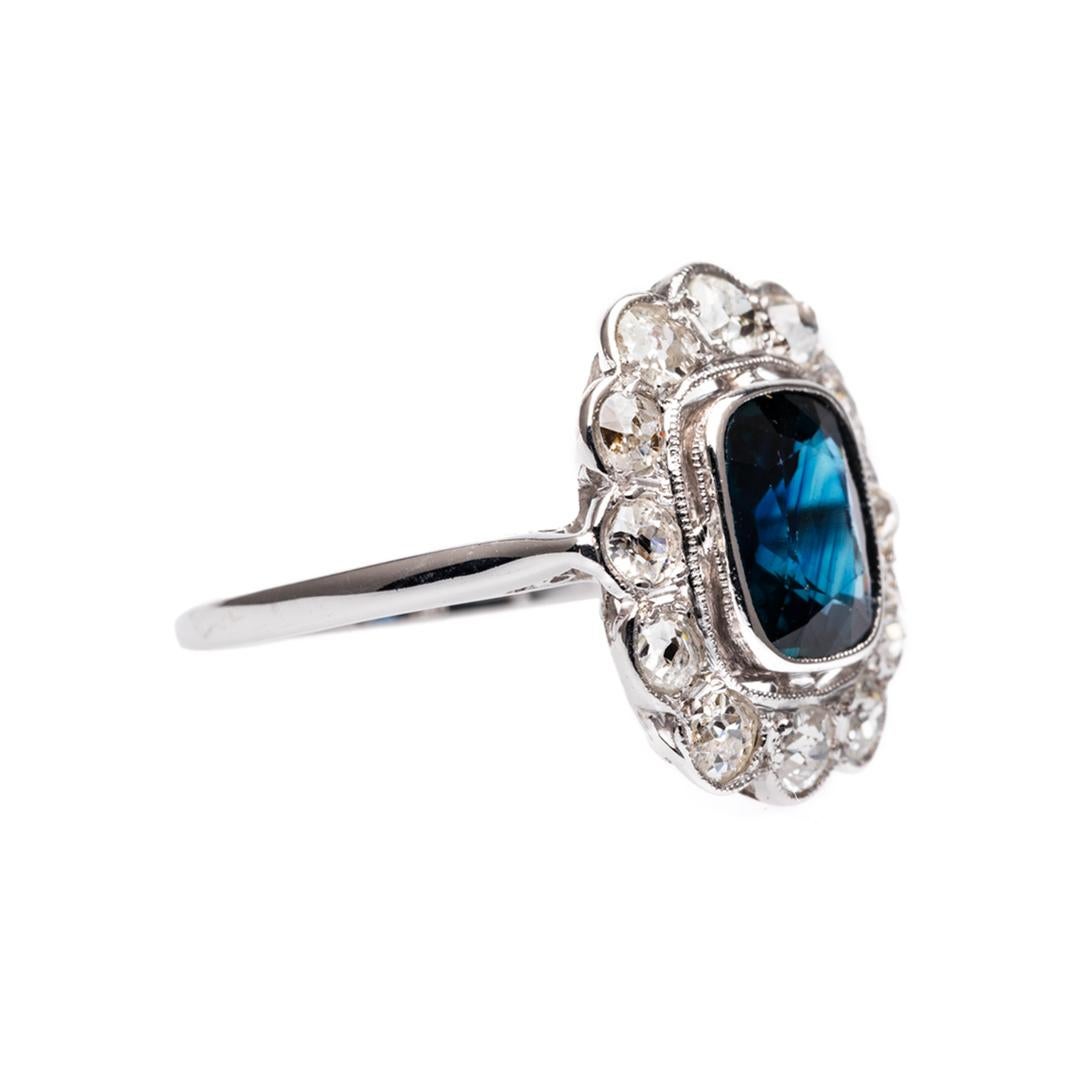 Quintessential beauty through stylish geometric design. Featuring an approximately 1.75 carat midnight blue sapphire elegantly surrounded by approximately 1.00 carats of old cut diamonds. Hand crafted in 18k white gold. Stamped with French
