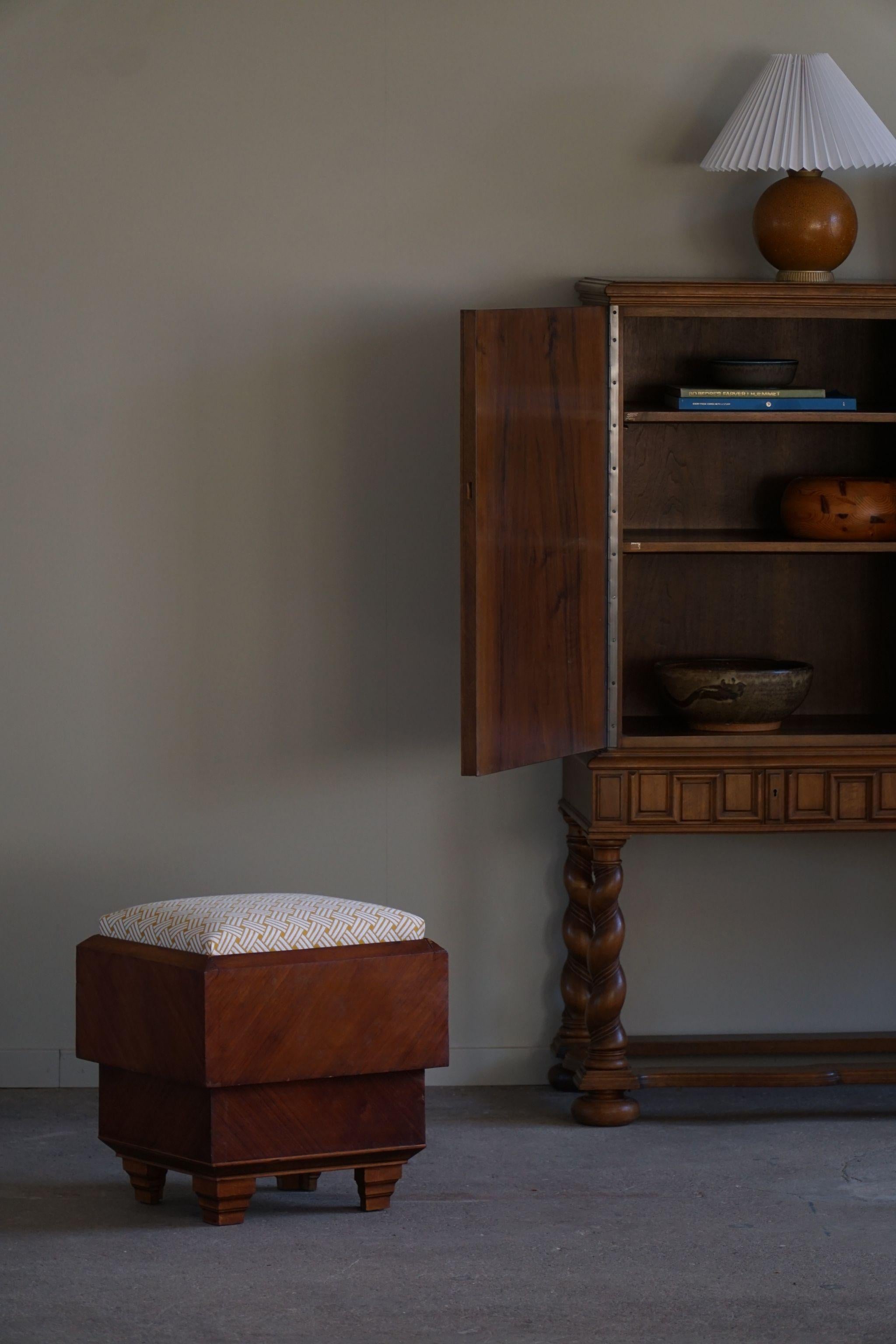 A luxurious square Art Deco stool with a fine storage room underneath the seat. Teak veenered and reupholstered a glamorous golden fabric. Made by a French cabinetmaker in the 1930s.

This nice vintage stool will fit in many interior styles. A