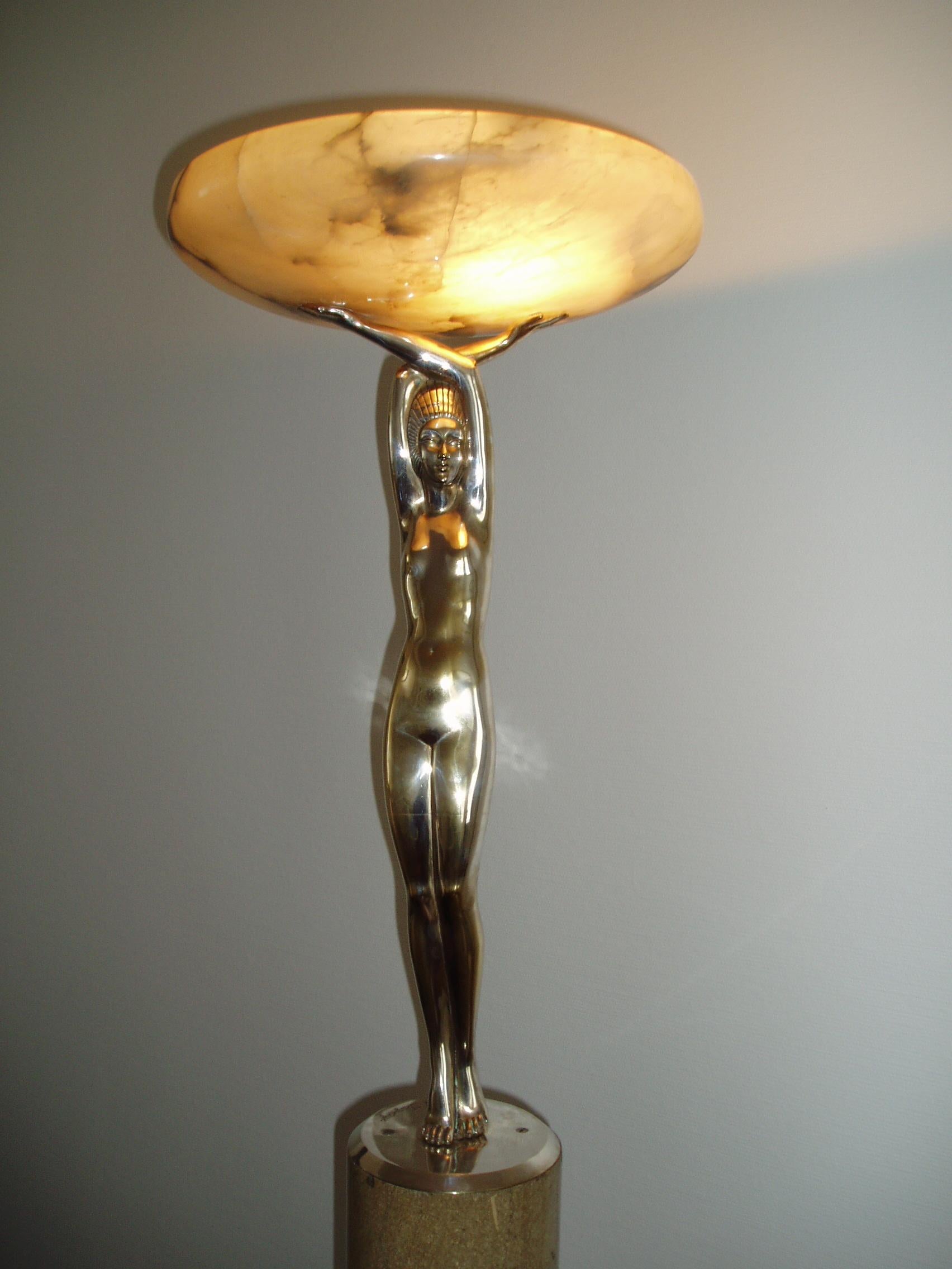 Silver-plated signed Art Déco bronze sculpure by Pierre le Faguays on a high stone base. 1920s. The figure carries an illuminated alabaster bowl on its hands. High heavy beige stone base.
Original alabaster bowl from the 1920s.
Pierre le Faguays