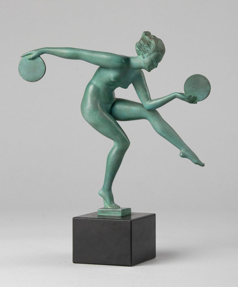 Beautiful Art Deco figurine of a dancing lady with discs in her hands. The statue is made of 'metal d'art', a special kind of spelter / bronze, which was casted in the studio of Max Le Verrier. The statue stands on a marble base. The statue is