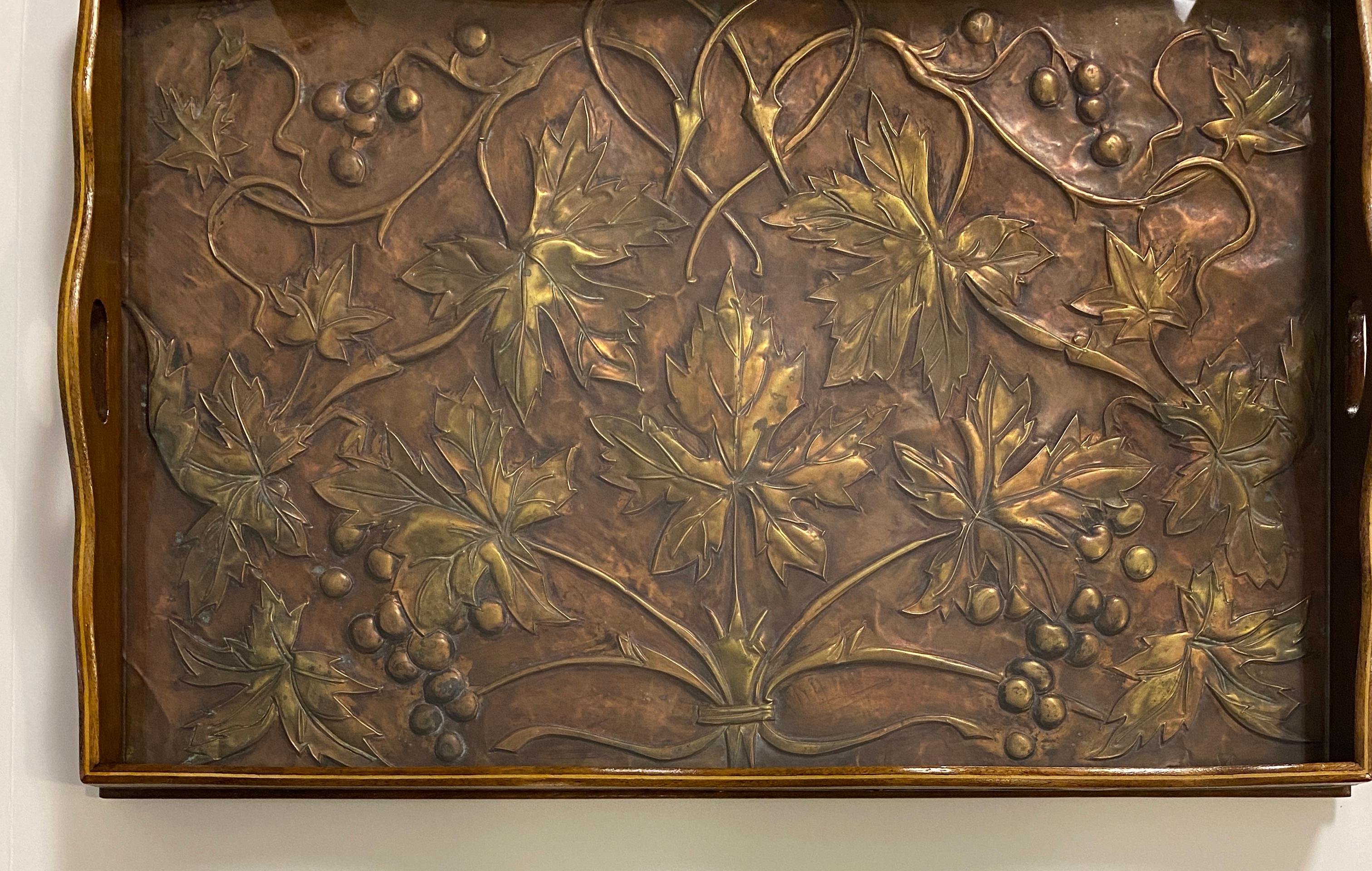 Dieses einzigartige und seltene französische Art-Déco-Serviertablett ist ein beeindruckendes Beispiel für großartiges Design. Es ist aus reichem Mahagoniholz handgefertigt und verfügt über eine atemberaubende Kupferintarsie unter Glas, die die