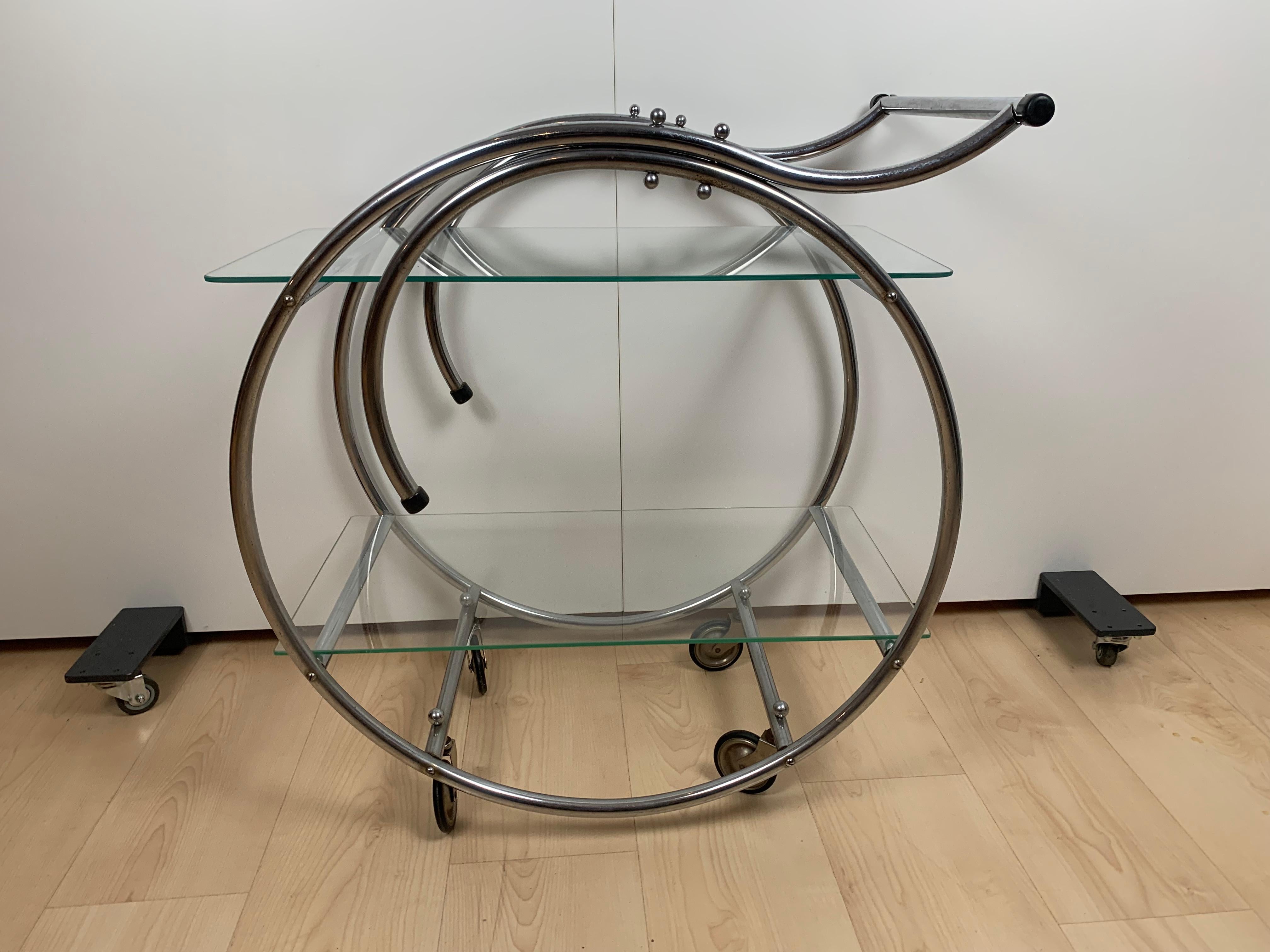 Chromed, bent steel tube. Mobile on 4 old rubber wheels. 2 glass plates.

Dimensions: H 73 cm x L 70 cm x W 40 cm.