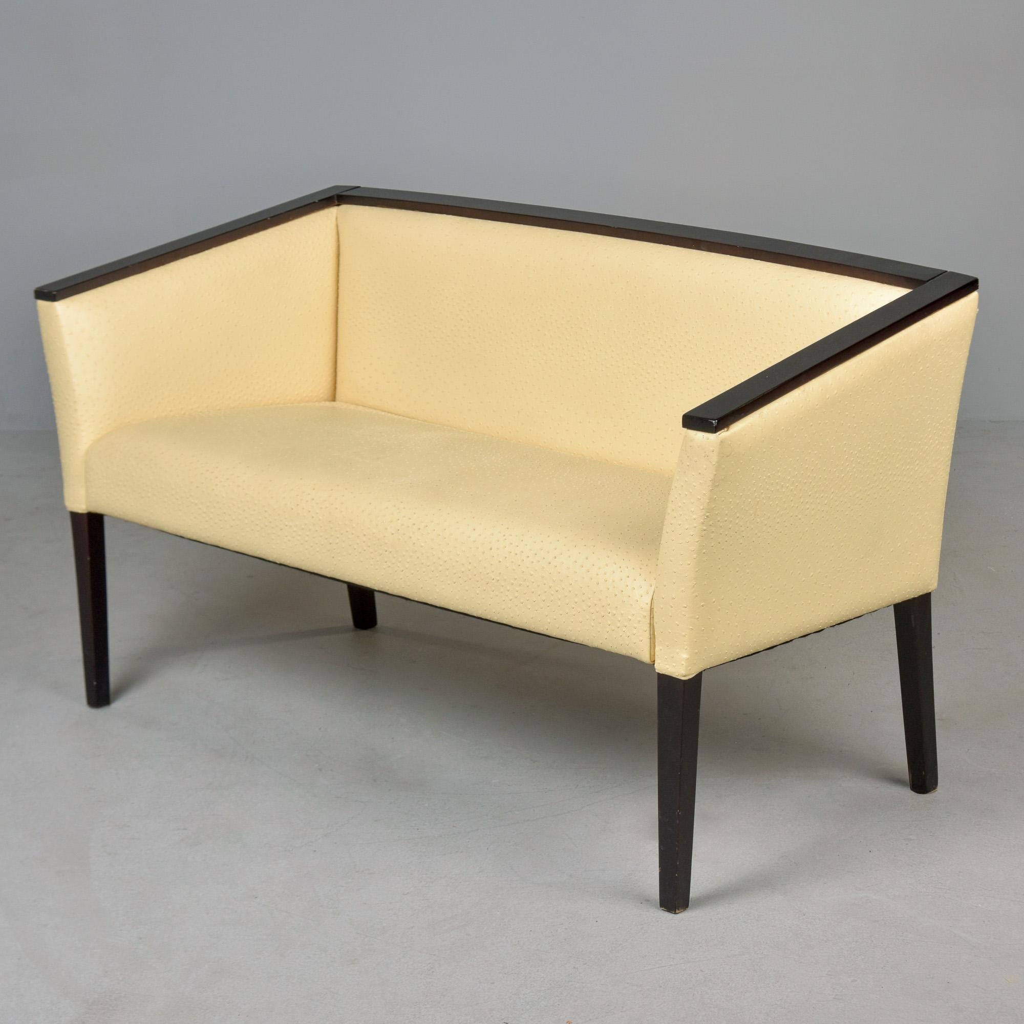 Found in France, this French Art Deco-era settee dates from the late 1930s / early 1940s. Newly upholstered in cream colored leather with ostrich-like surface texture. Black finished wood frame has clean lines that mix well with modern decor.