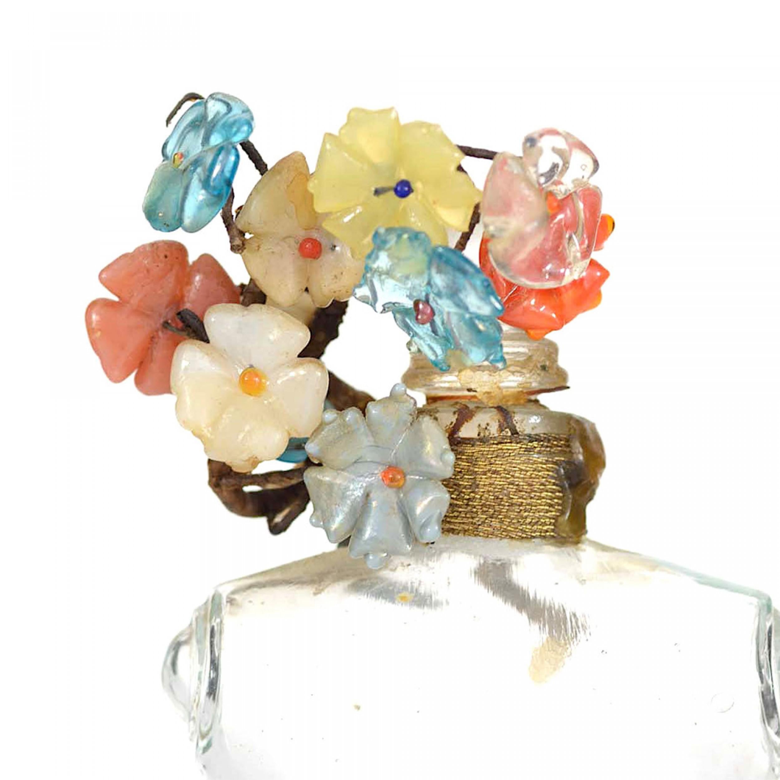 Bottiglia di profumo in vetro trasparente francese Art Deco rettangolare (SHOCKING di Schiaparelli) a forma di busto femminile di manichino da sarta, con fiori di vetro multicolore avvolti intorno al collo e un tappo di vetro a forma di palla.