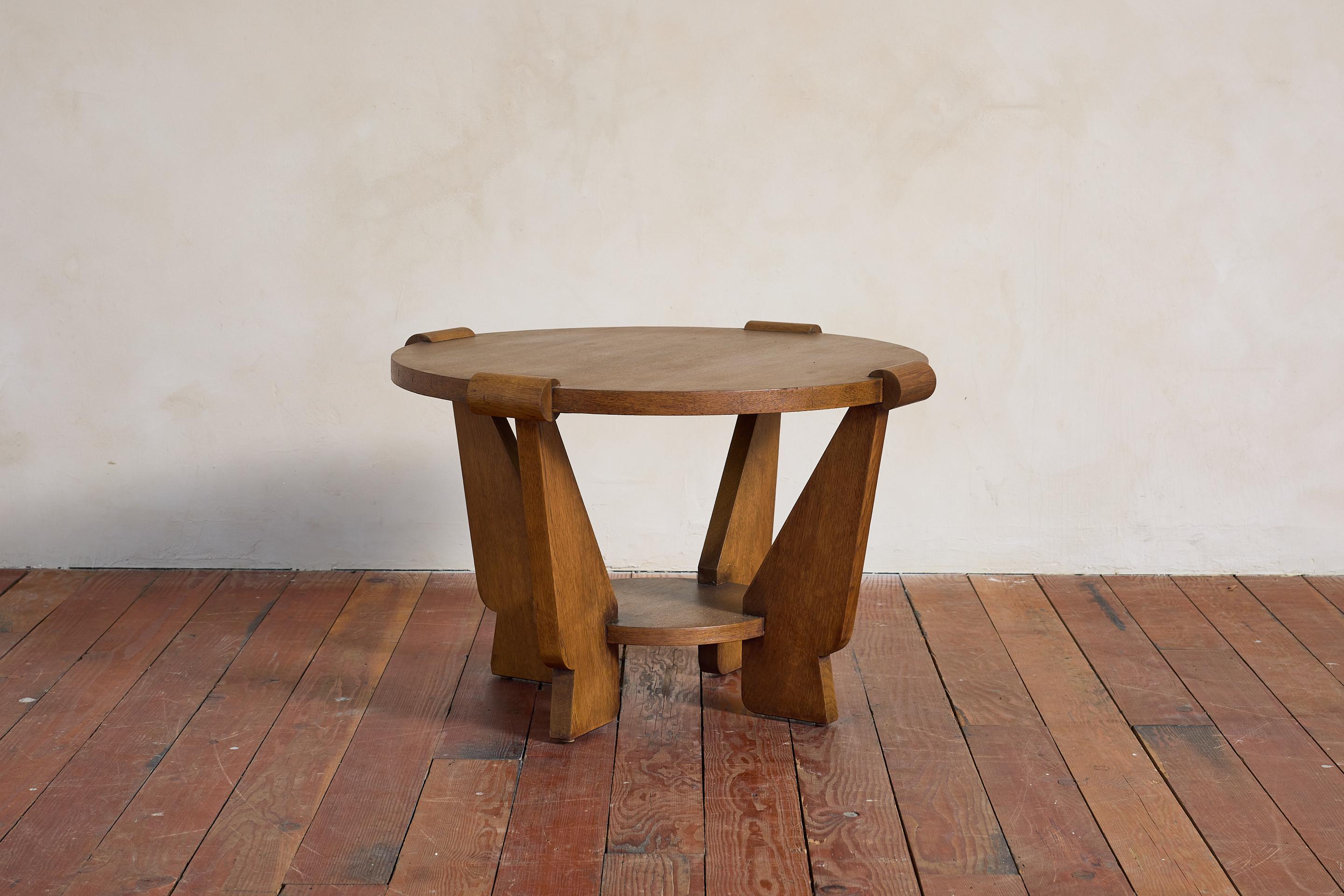 Incredible Art Deco Oak Side Table, France, 1930s

Beautiful thick oak wood with great patina.  Featuring circular top and angular legs and dowel-like corner detailing. 
Lower shelf floats within the leg
Solid oak construction with a beautiful, warm