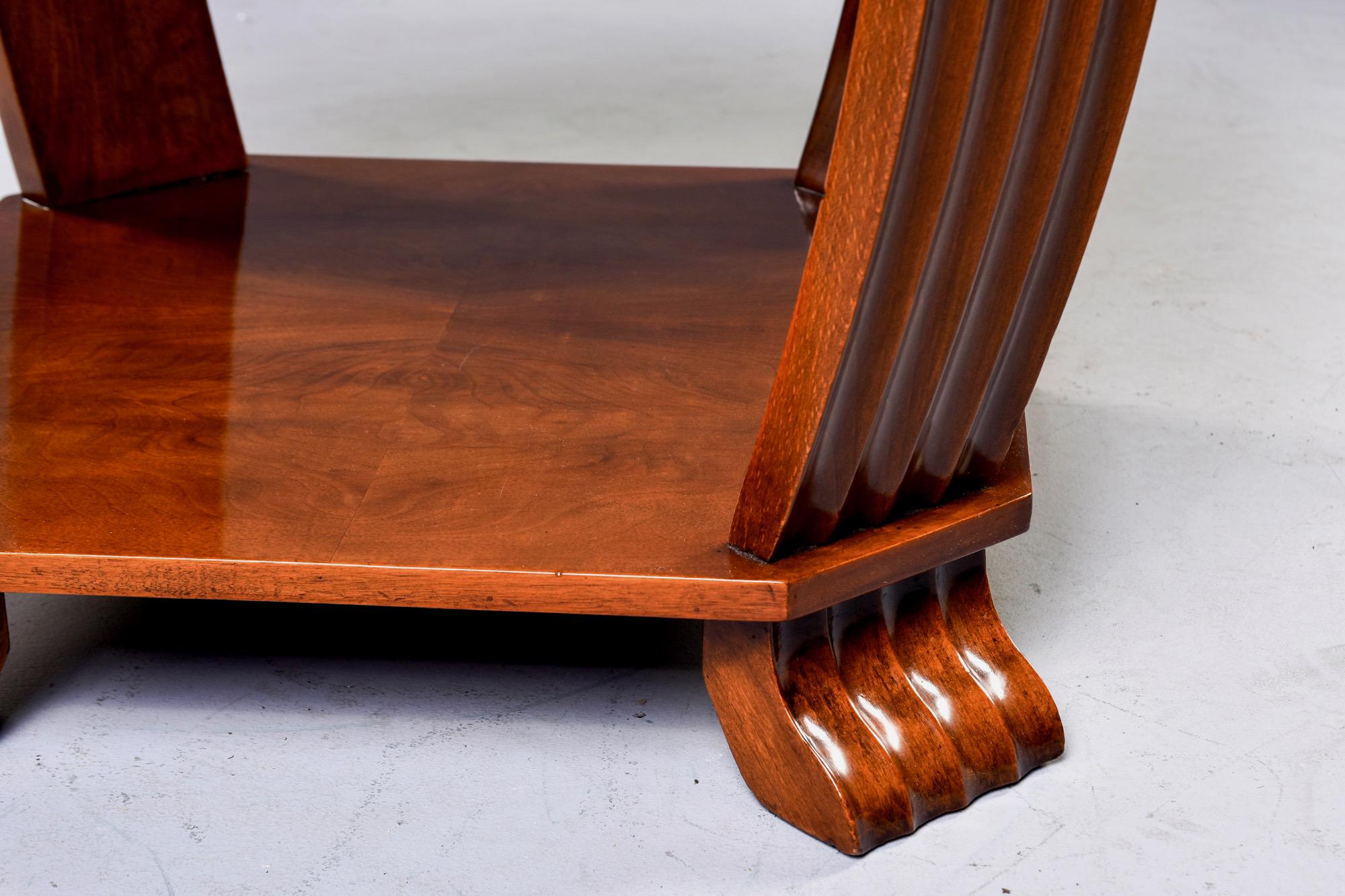 Achtseitiger französischer Art-Déco-Tisch aus Nussbaumholz mit schwarzer Lederplatte, um 1930. Gerippte Stützen/Beine und Füße, untere Etage mit buchfarbenem Furnier. Unbekannter Hersteller. Insgesamt sehr guter Vintage-Zustand.