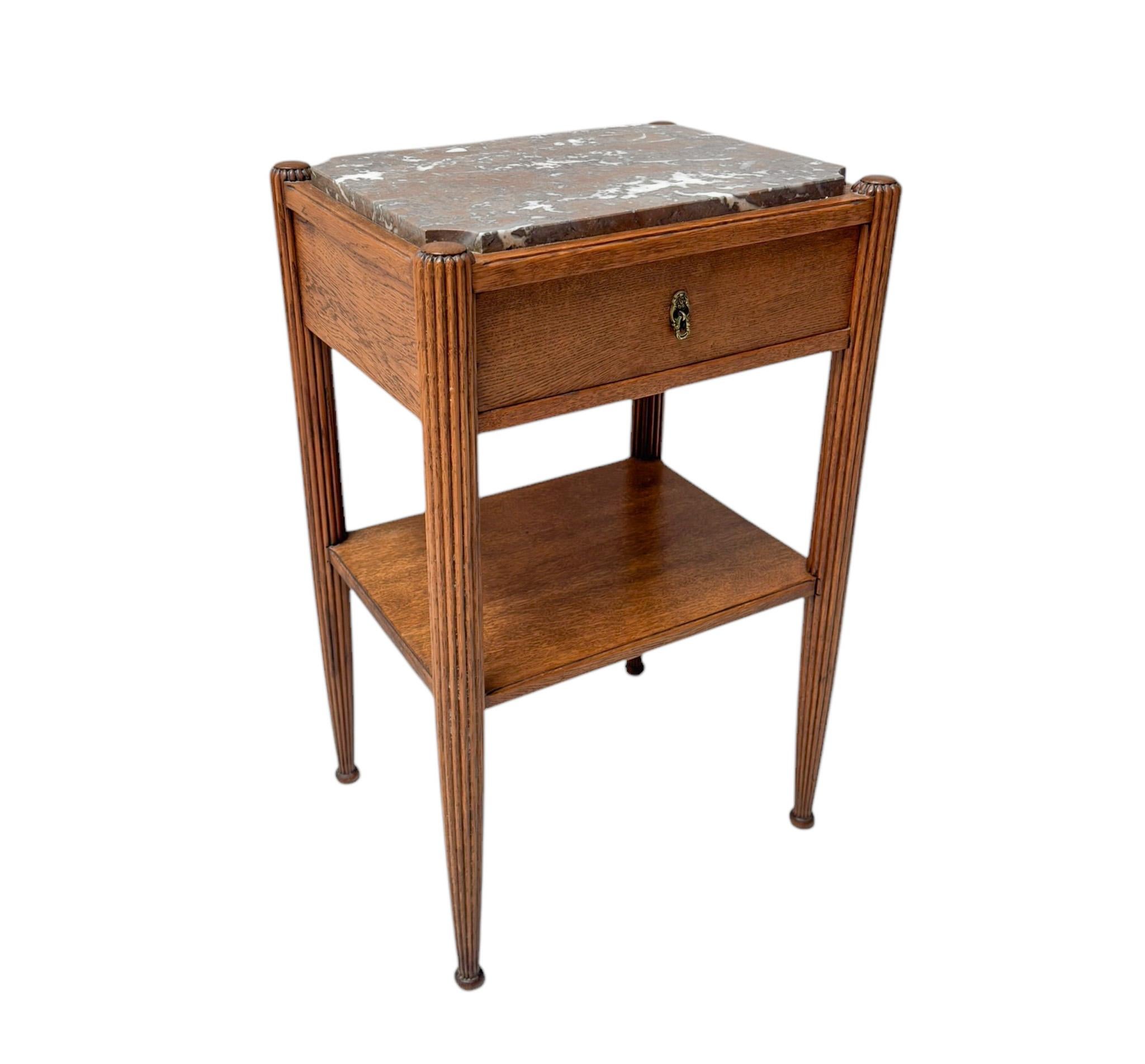 Stunning and rare Art Deco side table.
Striking French design from the 1930s.
Solid oak with original colored marble top.
The drawer has the original brass handle.
This wonderful Art Deco side table is in very good condition with minor wear