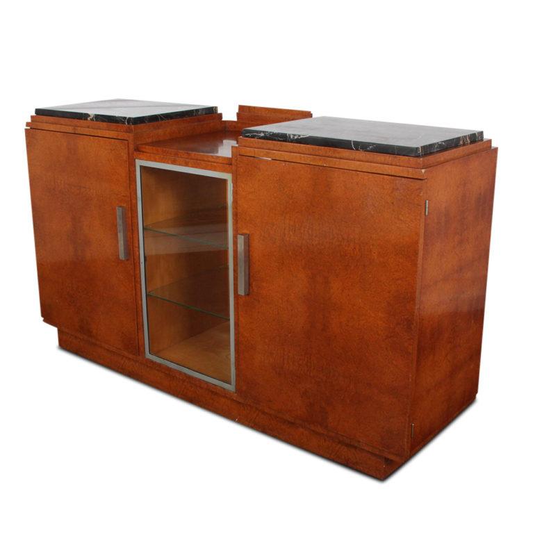 A French Art Deco buffet with exotic burl wood surfaces, the side cabinets with ample storage, inner fitted drawers and raised Portoro marble tops and flanking a lower central display cabinet with glass shelves and glass door.

Stylish geometric