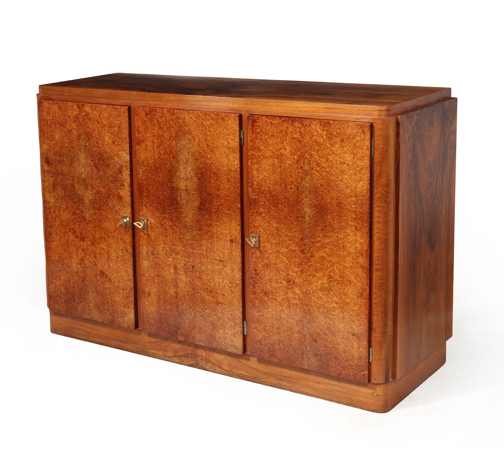 FRENCH ART DECO SIDEBOARD 
A stunning French Art Deco sideboard in walnut with highly figured Amboyna doors, each lockable with 3 keys two long adjustable height shelves behind, the sideboard has been carefully restored and fully polished by hand