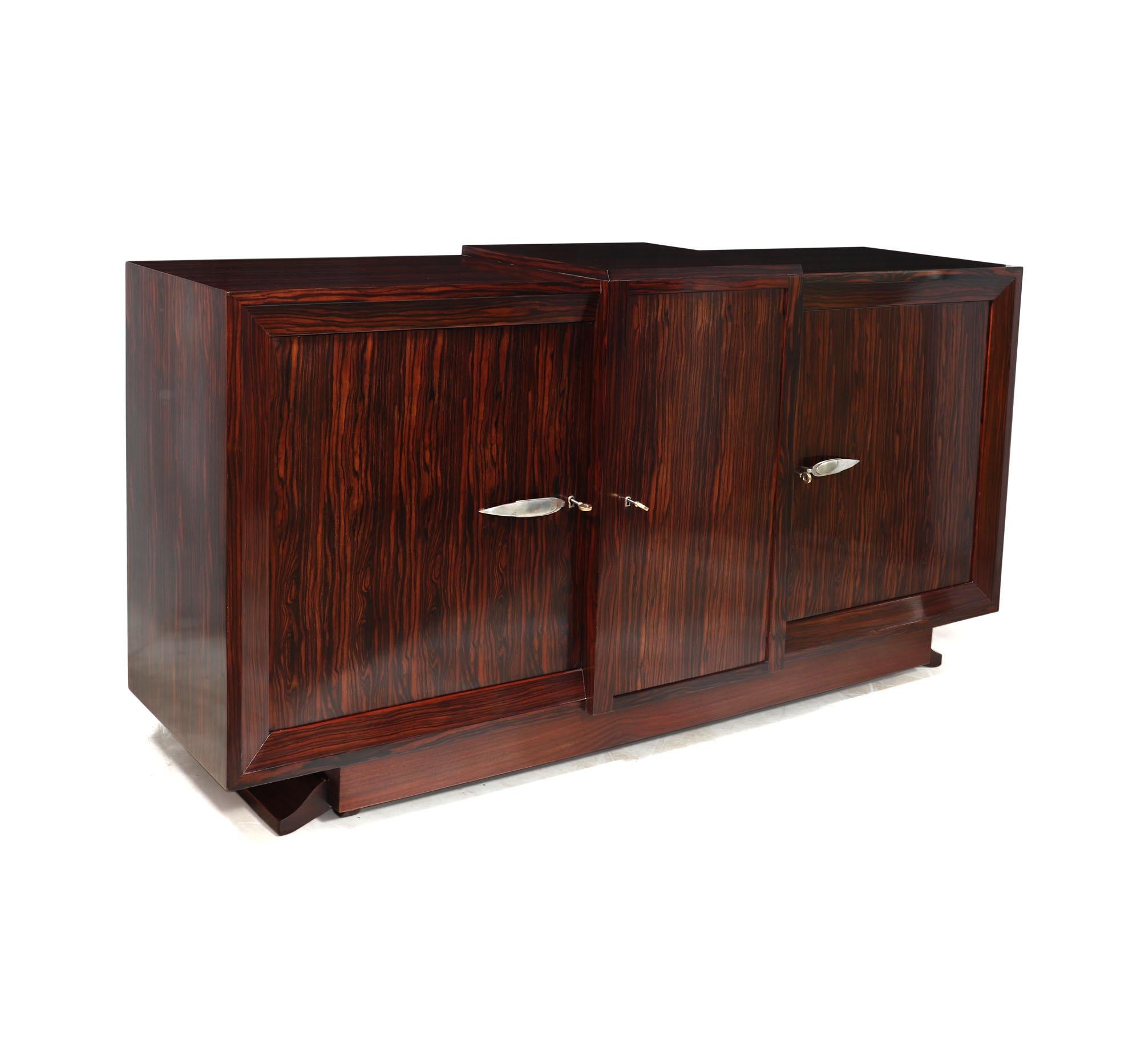 FRENCH ART DECO SIDEBOARD
A stunning French Art Deco sideboard in Macassar Ebony, this elegant piece was produced in France during the 1930s. The attention to detail is evident throughout, with three lockable doors featuring silvered leaf shaped