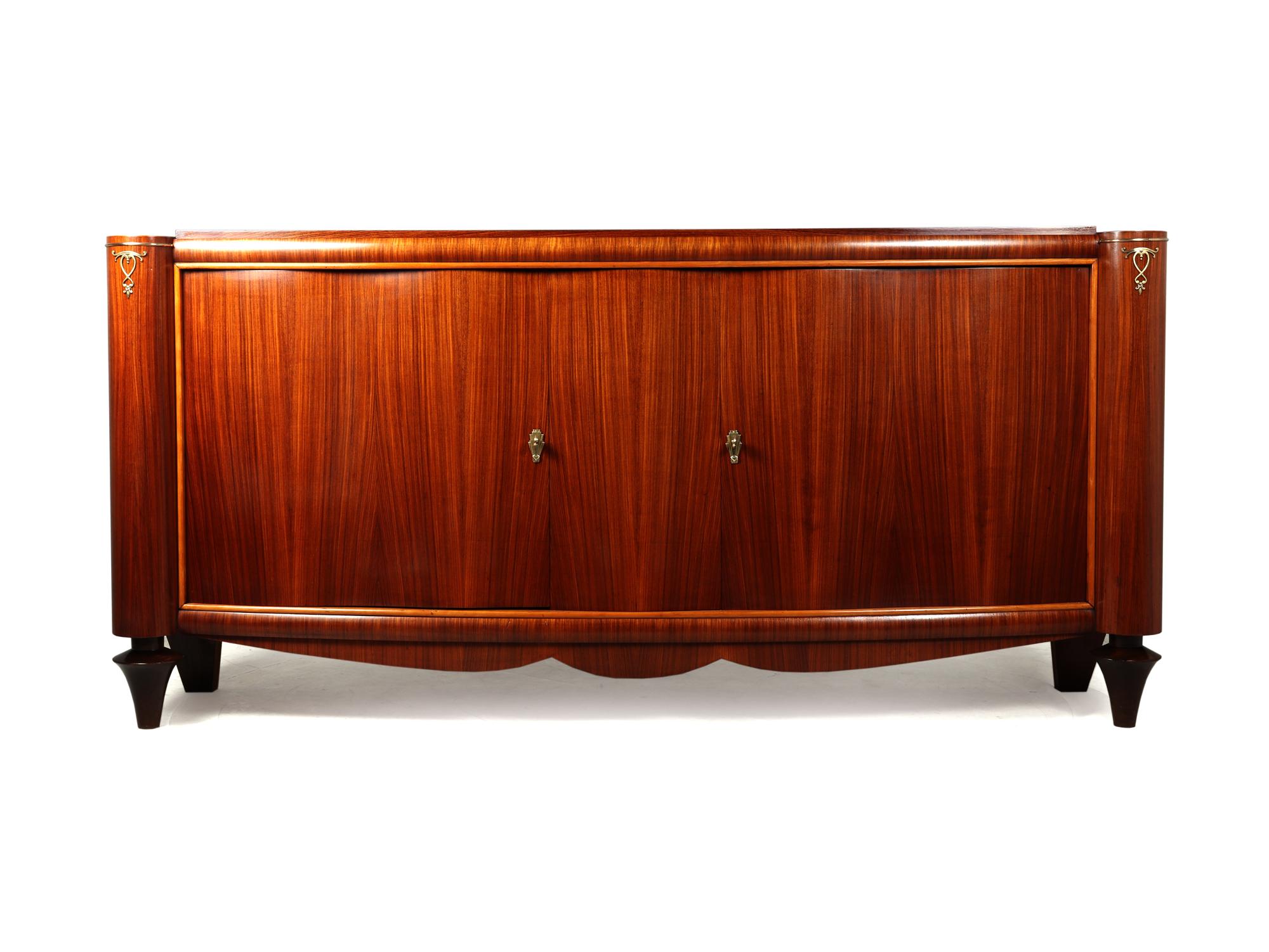 A large French Art Deco sideboard very much in the manner of Jules Leleu produced from Palisander in France in The 1930’s, the sideboard has two large shaped opening doors with shelf behind

the sideboard has been full polished by hand and is in