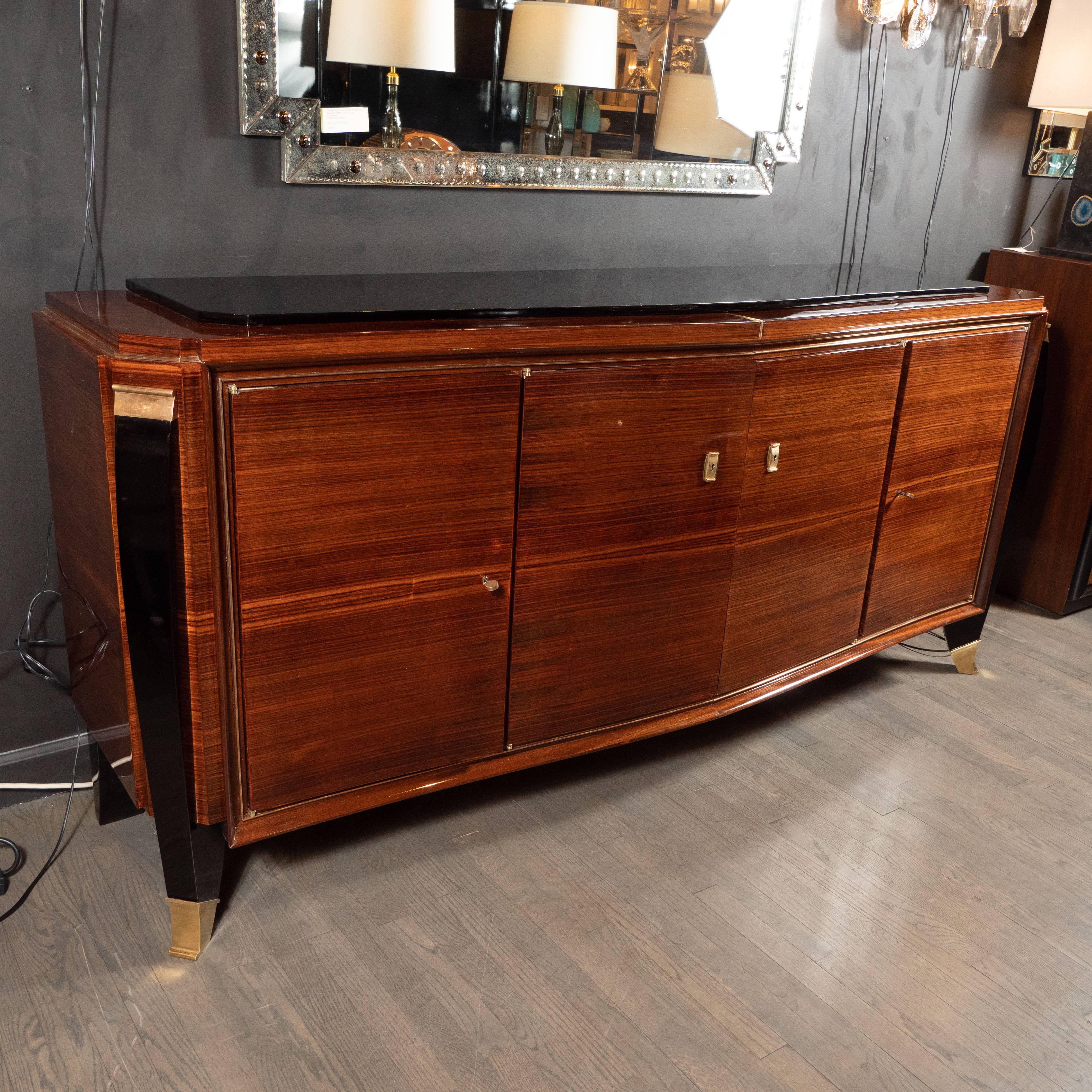 This elegant Art Deco sideboard was realized in France, circa 1935. It offers the impeccable craftsmanship and subtle detail that discerning collectors of the period cherish. It is composed of a rectangular form with cut corners and a gently bowed