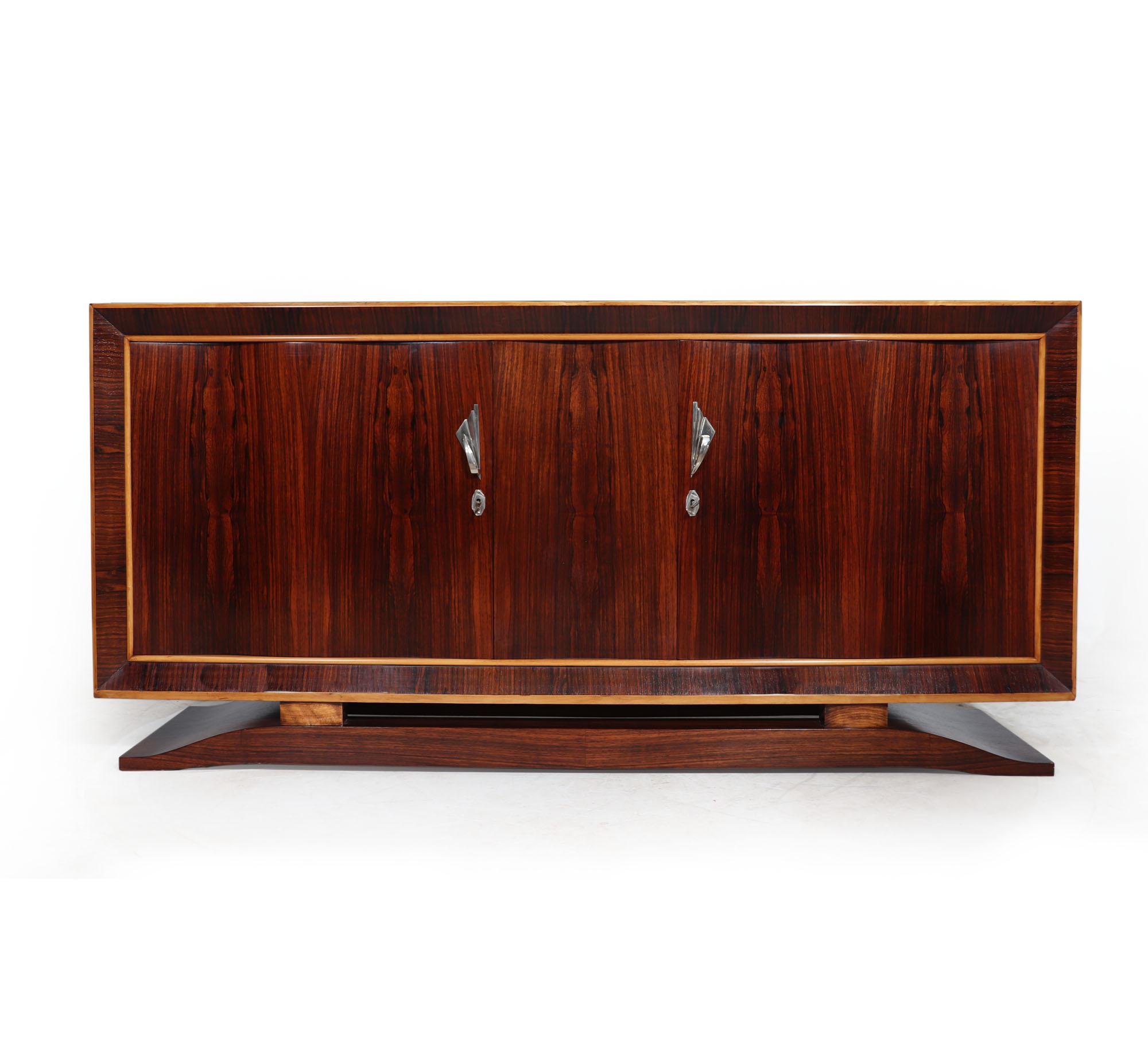 The French Art Deco Sideboard in Rosewood is a beautiful piece of furniture that makes a lasting impression. The sideboard is crafted from rosewood and features two shaped doors with silvered handles, creating a classic look. It has plenty of