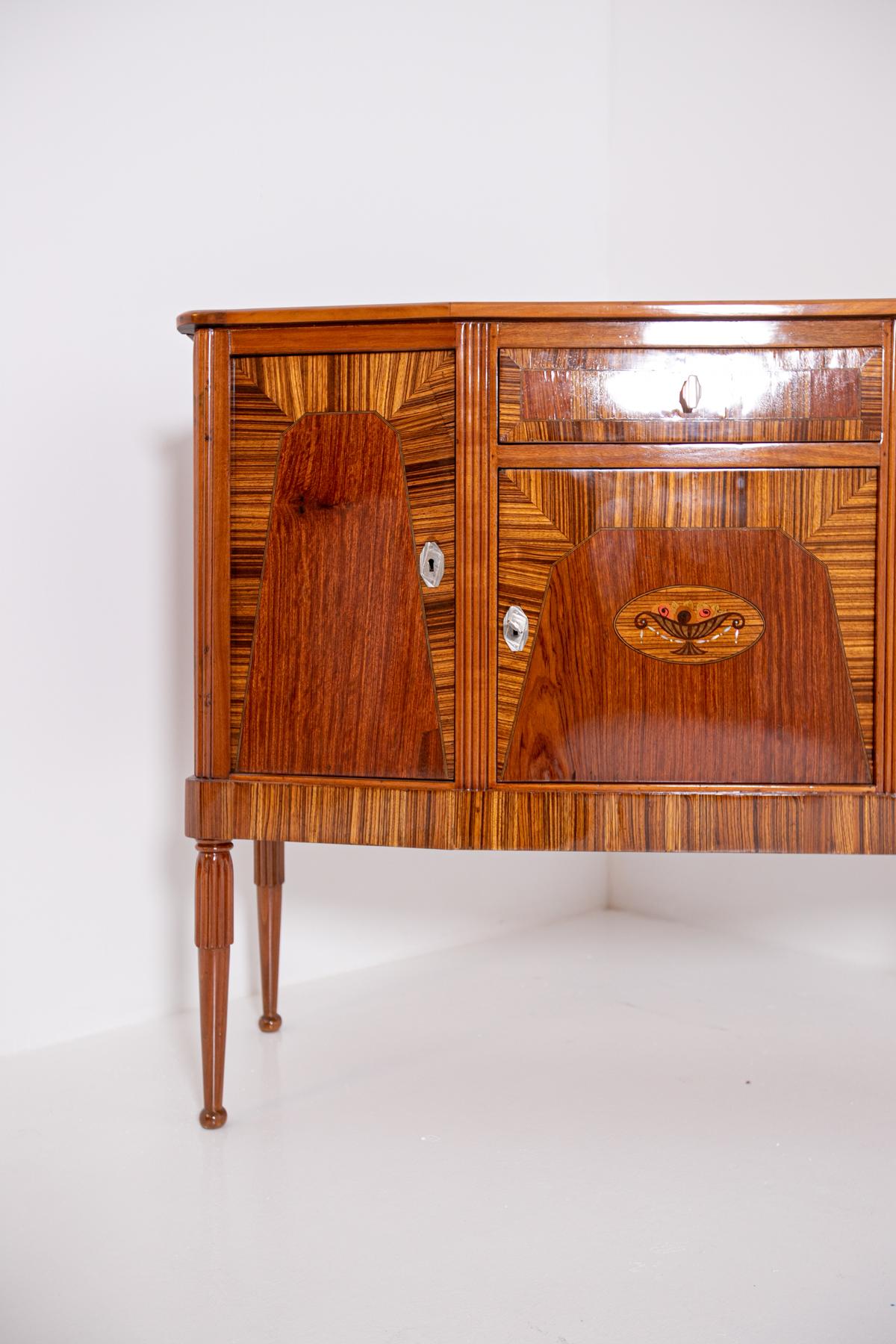 Refined French sideboard from the 1930s. The sideboard is made of different types of wood.
The particularity of the sideboard is its great mastery of woodwork. It has three hinged doors with a pull-out drawer under the shelf. Its doors can be