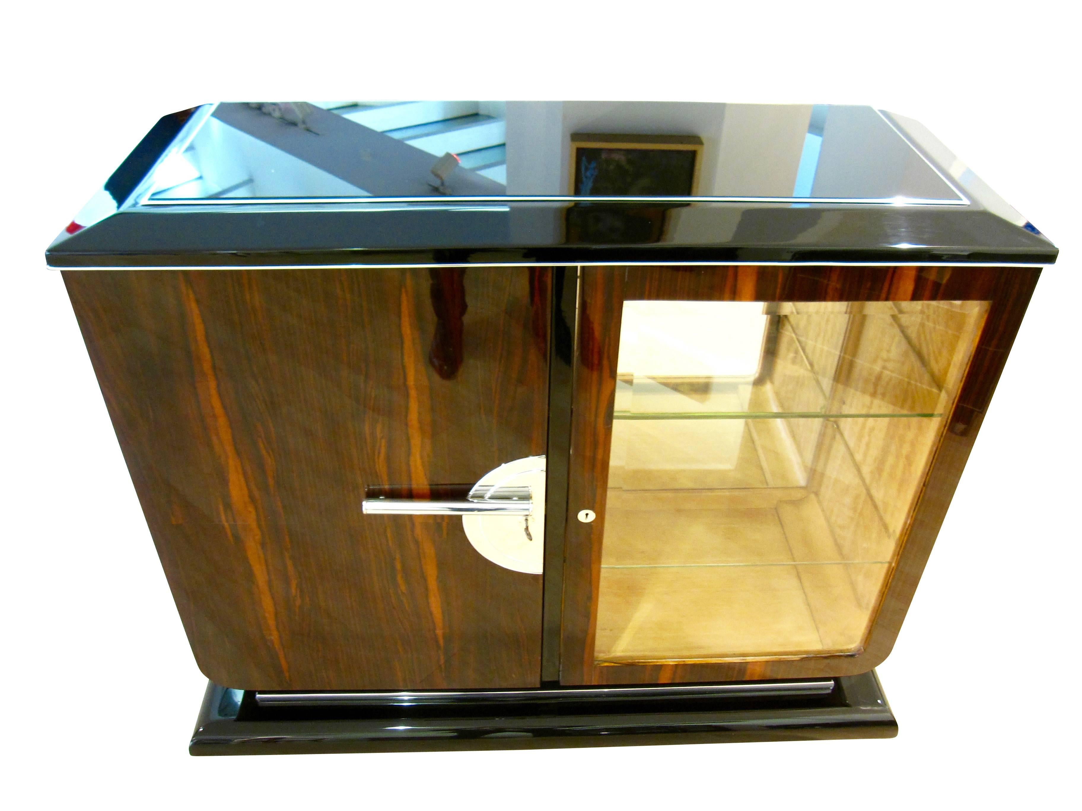 Elegant Art Deco sideboard in Macassar from France, circa 1925.
 
The front and both sides are veneered with Macassar of an especially beautiful grain. Bottom and top are black lacquered wood and polished to high-gloss.
There is an integrated bar
