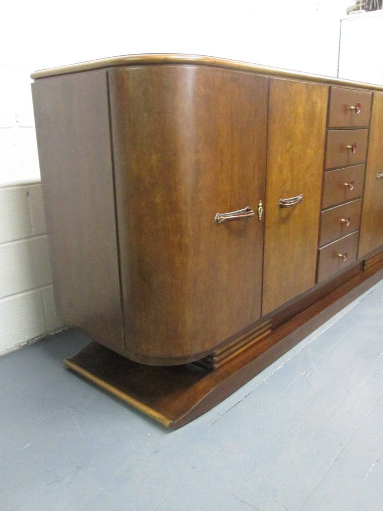 French Art Deco sideboard or buffet. Has Bakelite handles, curved sides, five pull-out drawers and behind each cabinet doors are two adjustable shelves.