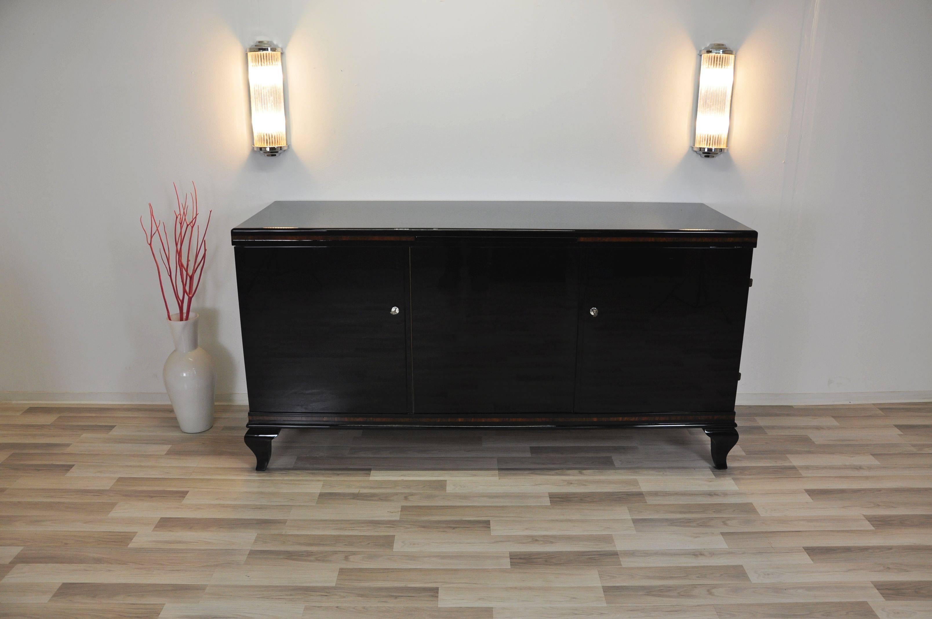 Simple sideboard with great feet from the Art Deco era. The elegant and plain design is complemented with beautifully carved feet. You will find cherry wood details on the top and bottom plates. The complete body is painted with our signature black