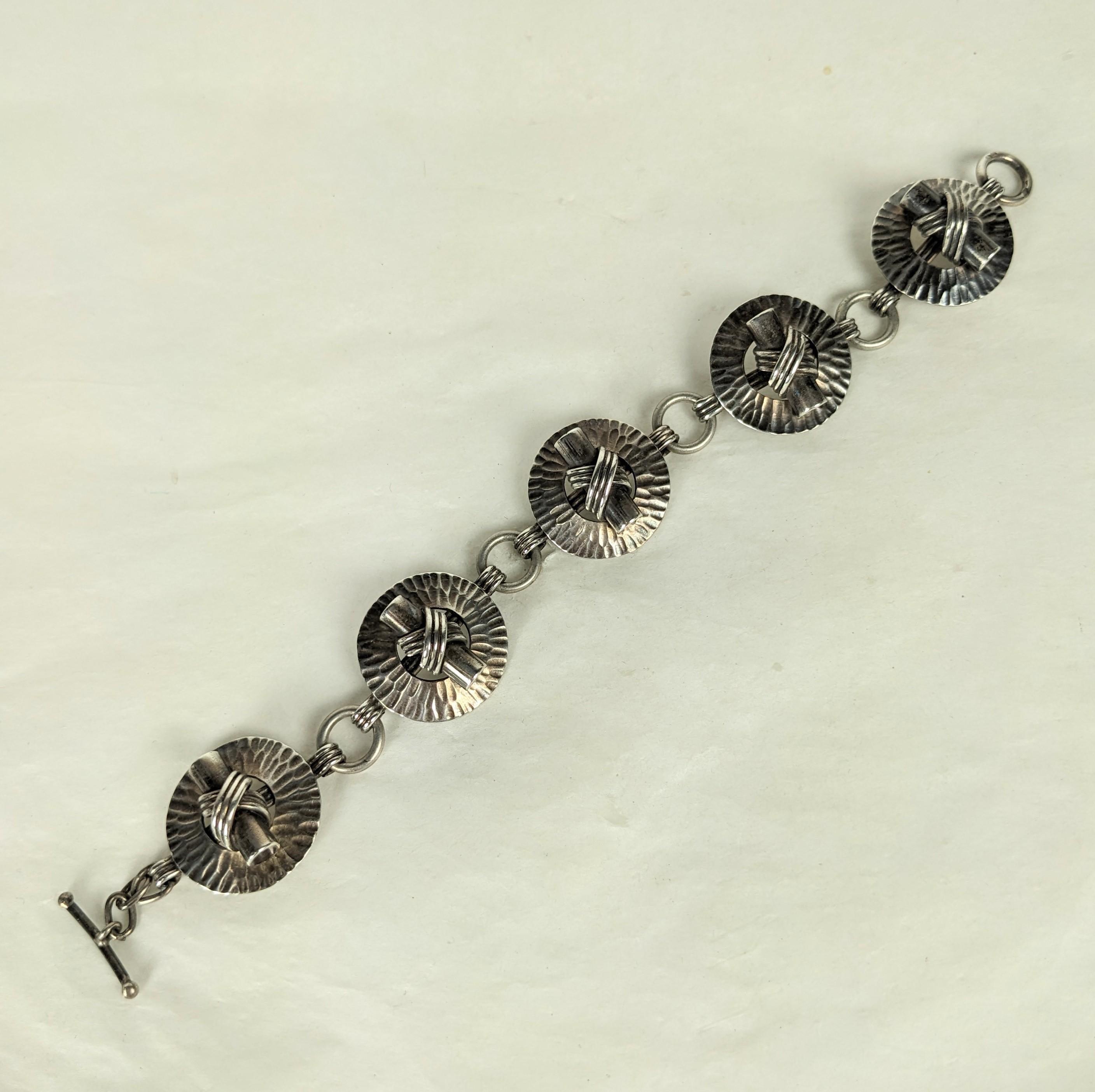 Französisches Art-Déco-Silberarmband von Fernand Grange aus den 1930er Jahren. Unglaubliches handgefertigtes Design aus gehämmerten Ringen mit dimensionalem, gebundenem Knebelmotiv. Ein ganz besonderes Design von einem Meister des Art Deco.