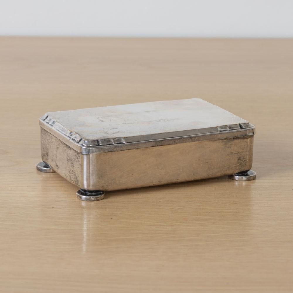 Scatola decorativa in argento Art Decor proveniente dalla Francia, anni '30. Scatola rettangolare su quattro piedini rotondi in argento. Interno in legno e dettaglio smerlato sul coperchio. La finitura originale mostra una buona età e patina. Timbro