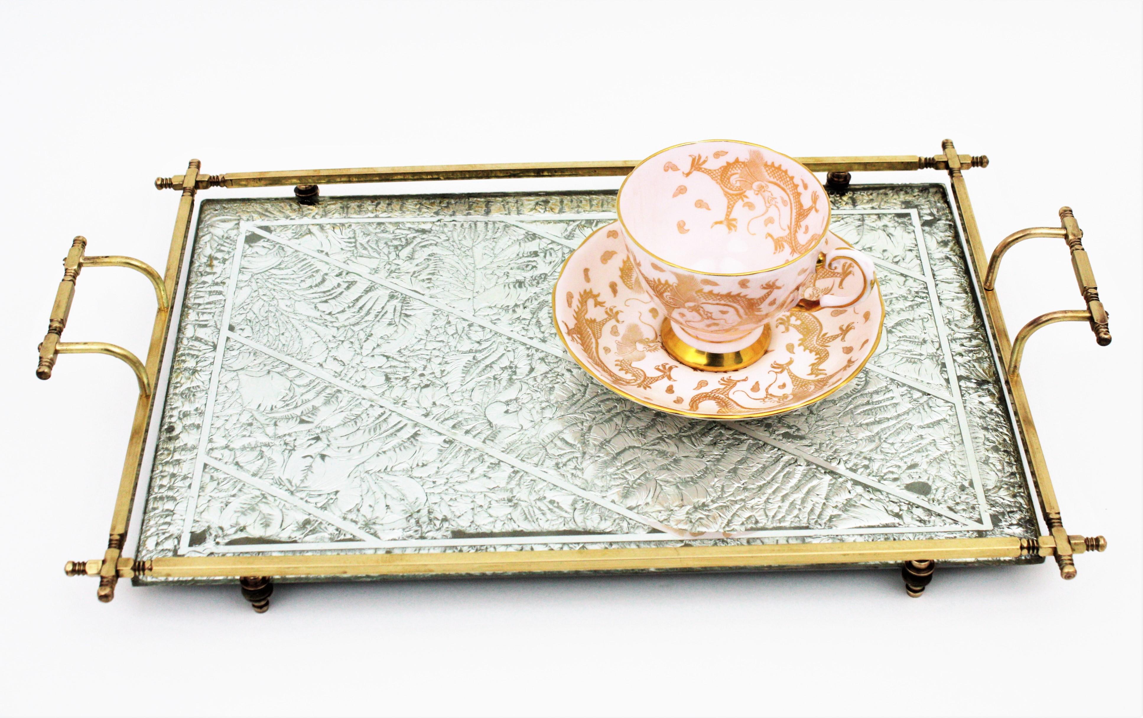 One of a kind Art Deco mirror and brass handled serving tray /vanity tray with silver leaf decorative motifs, France, 1930s.
The mirrored surface has silver leaf naturalistic decorations accented by stripes. It is suspended on a polished brass