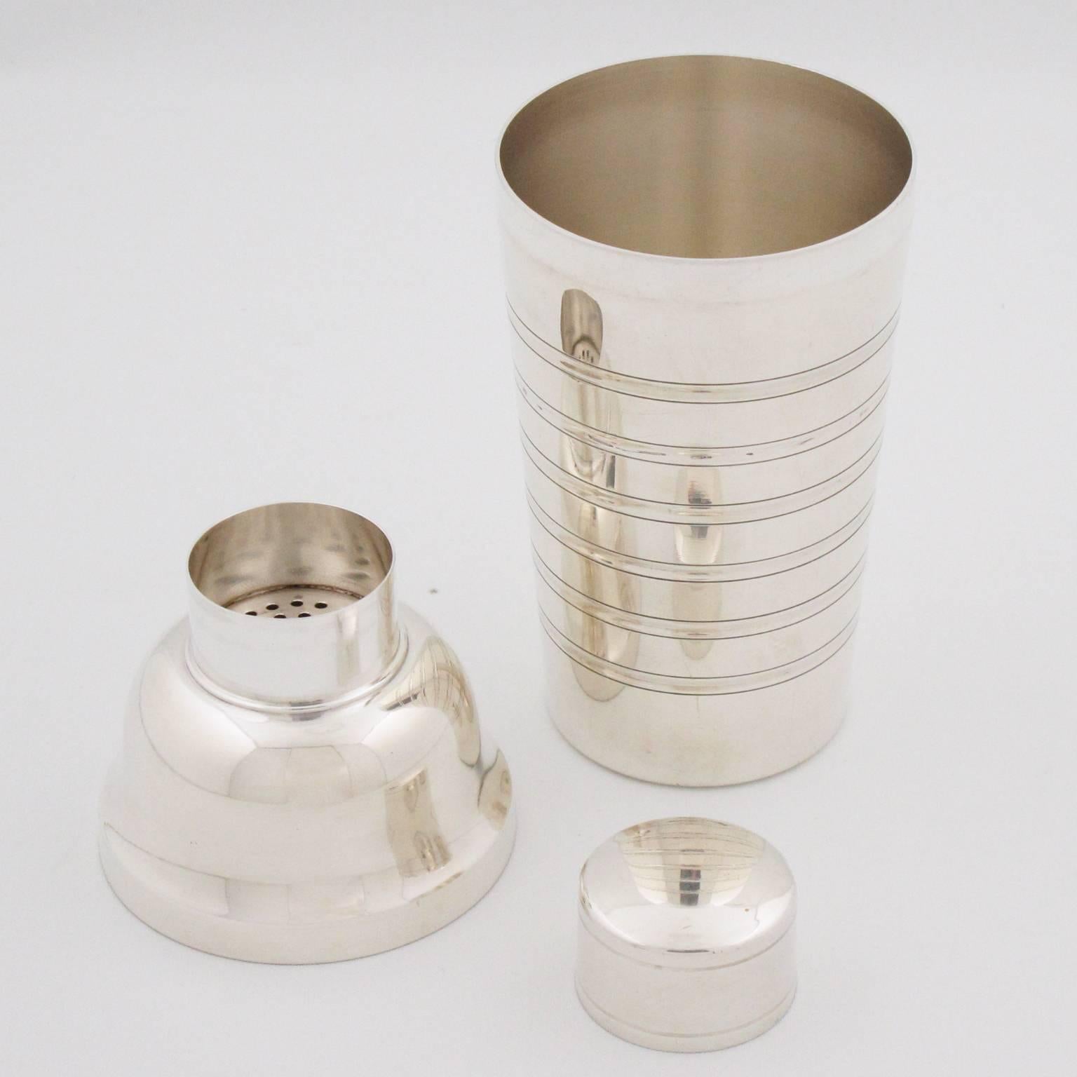 Elegant French Art Deco silver plate cylindrical cocktail or Martini shaker by silversmith Argit, Paris. Three sectioned designed cocktail shaker with removable cap and strainer. Lovely Art Deco design with six decorative bands of engraving. Marked
