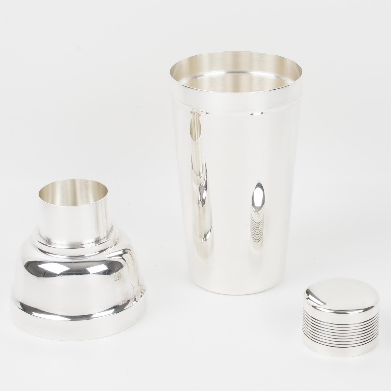 Elegant French Art Deco silver plated cylindrical cocktail or Martini shaker by silversmith Ercuis, Paris. Three-sectioned designed cocktail shaker with removable cap and strainer. Lovely Art Deco flair with geometric design and striped carving on