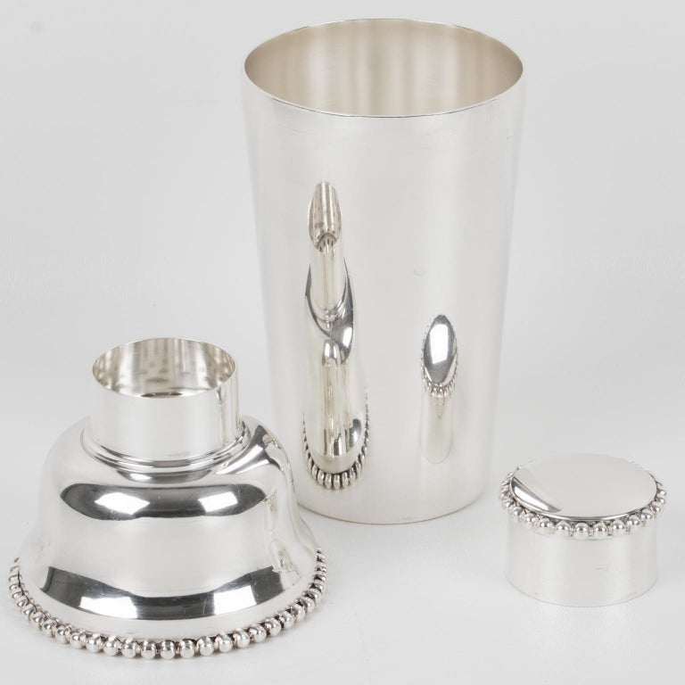 Elegant French Art Deco silver plate cylindrical cocktail or Martini shaker. Three-sectioned designed cocktail shaker with removable cap and strainer. Lovely Art Deco flair with geometric design and carved beading all around the strainer and the