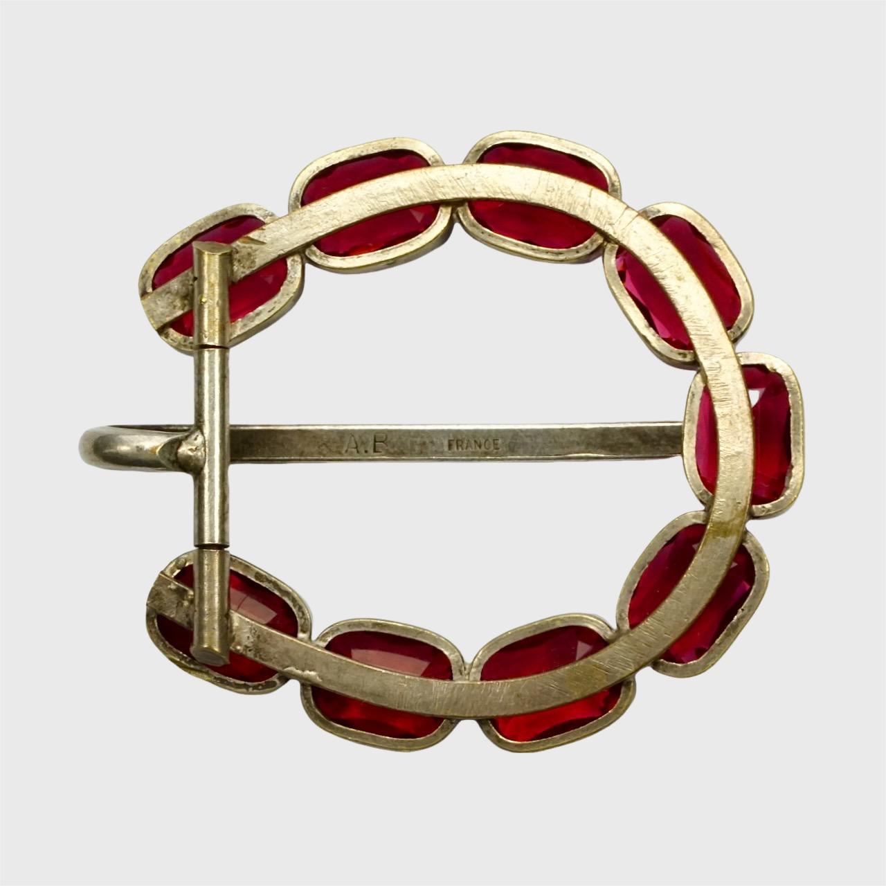 Beautiful Art Deco silver plated belt buckle featuring faceted garnet glass stones with millgrain edging decoration.  It is stamped A.B FRANCE. Measuring 5.7cm / 2.24 inches by 4.9 cm / 1.9 inches, it would fit a belt approximately 2 cm / .78 inch