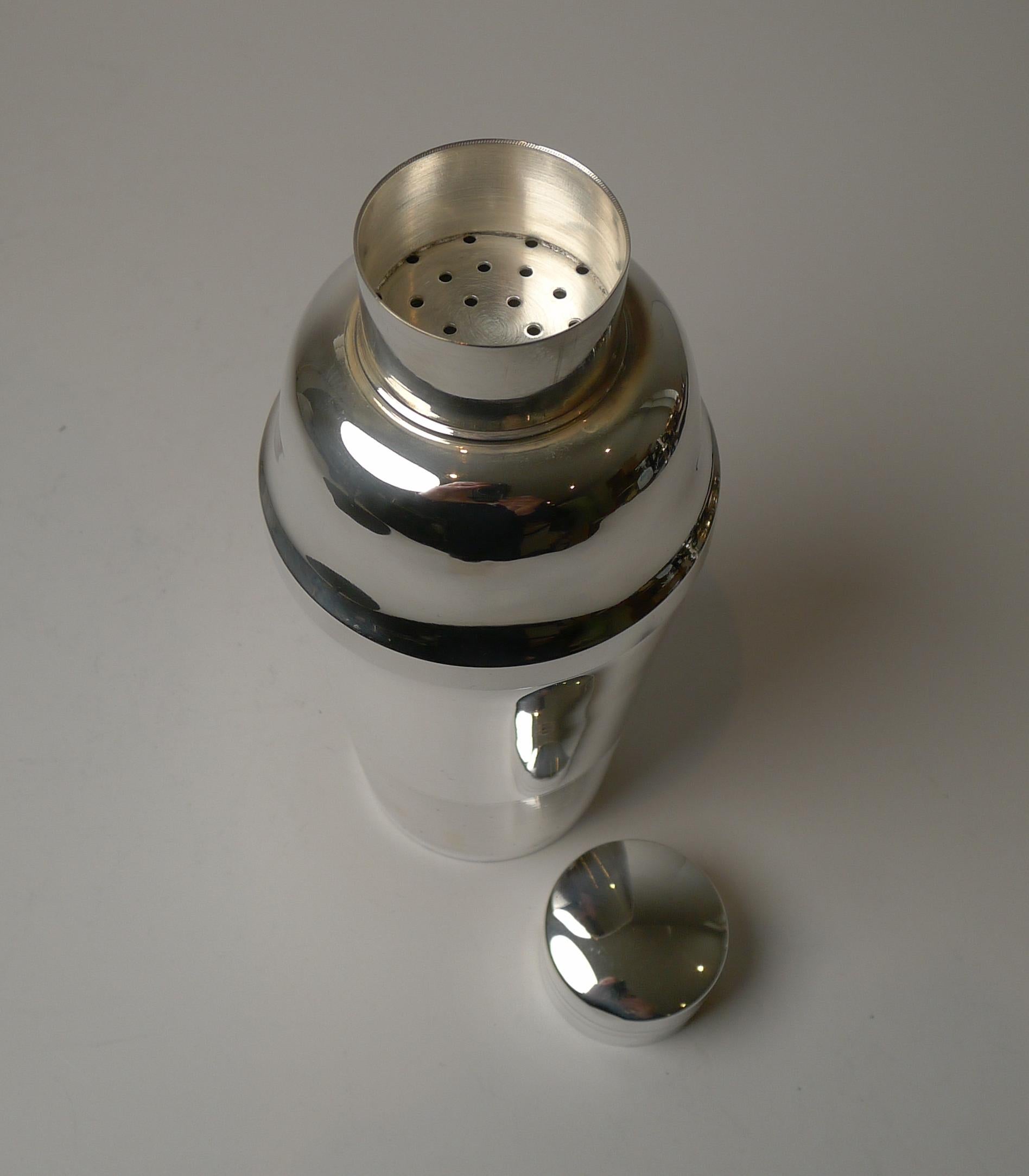 A handsome and unusual Art Deco cocktail shaker in silver plate and dating to c.1930/1940. An unusual design with the lower portion having a linear design with little polka dot engravings, a lovely decorative detail.

The underside is fully marked